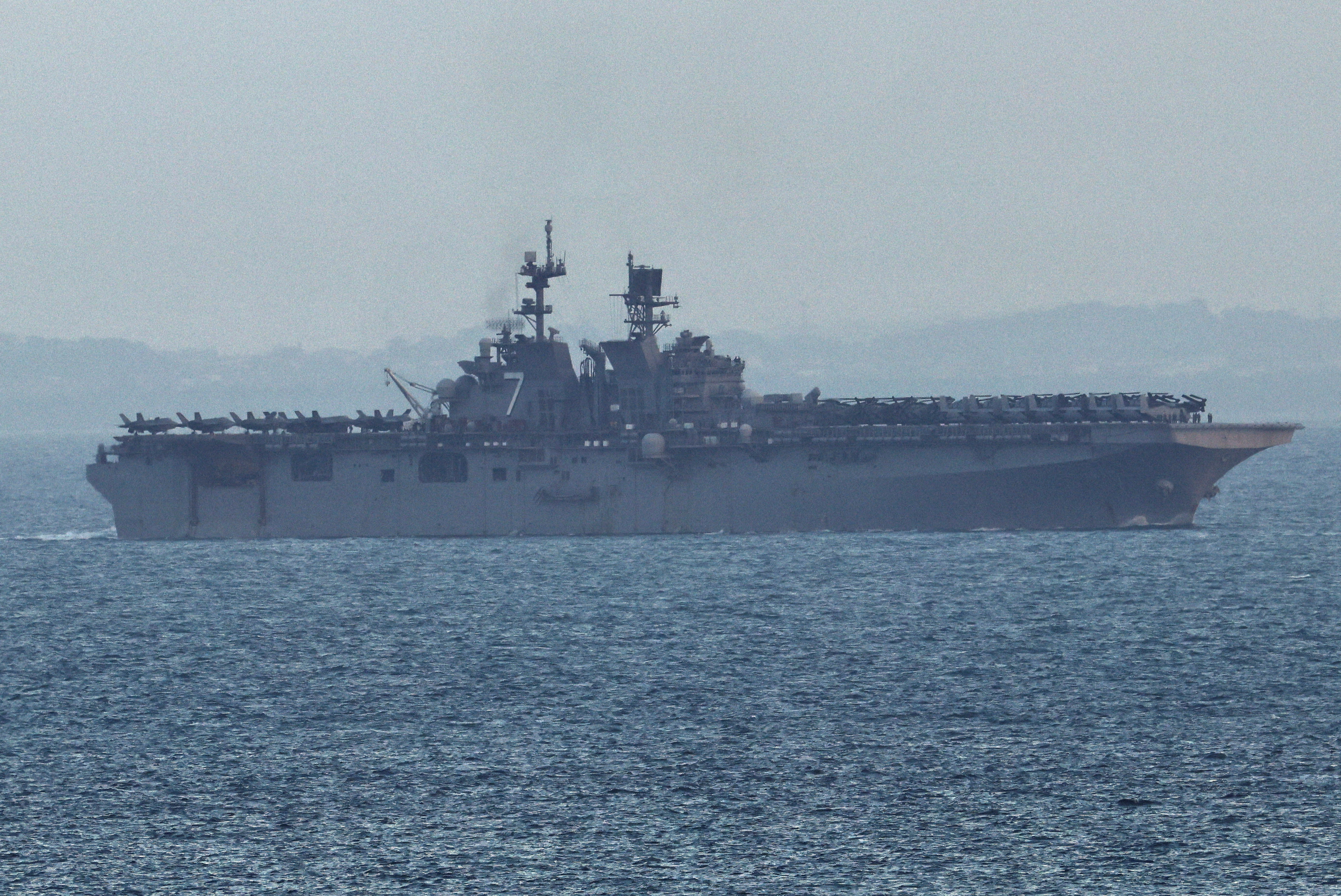 The USS Tripoli (LHA-7) amphibious assault ship enters the Singapore Strait, amid the U.S.-Israeli conflict with Iran, as seen from Singapore, March 17, 2026. REUTERS/Edgar Su REFILE - UPDATING TO FIX "STRAITS" TO "STRAIT