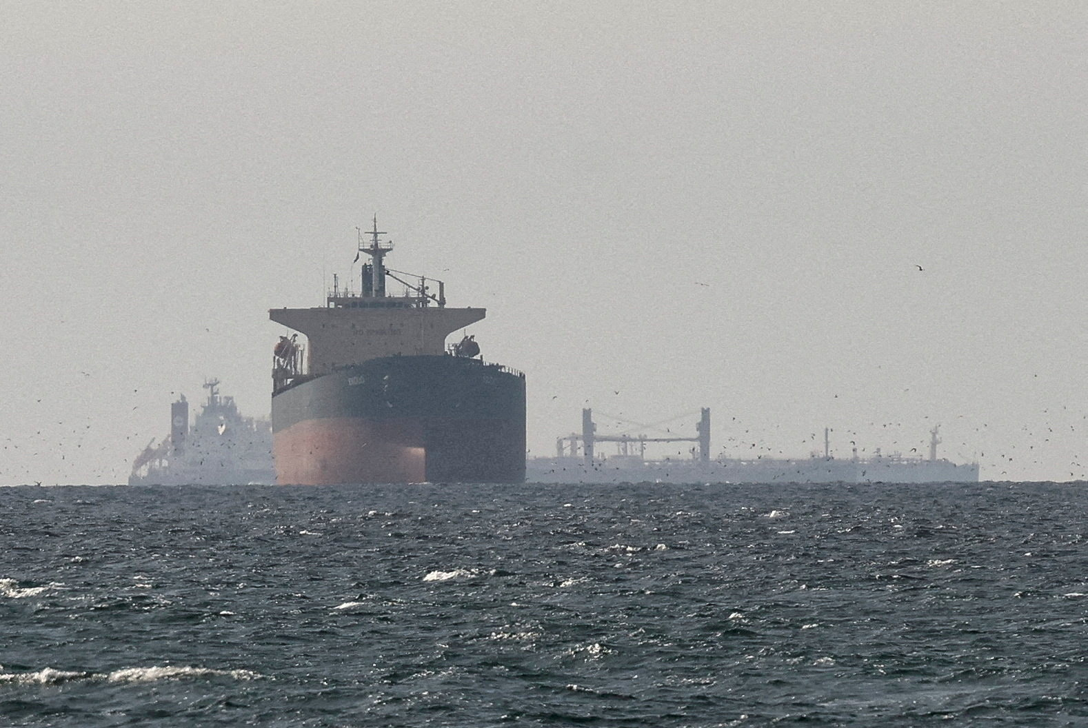 FILE PHOTO: Cargo ships in the Gulf, near the Strait of Hormuz, as seen from northern Ras al-Khaimah, near the border with Oman’s Musandam governance, amid the U.S.-Israeli conflict with Iran, in United Arab Emirates, March 11, 2026. REUTERS/Stringer//File Photo