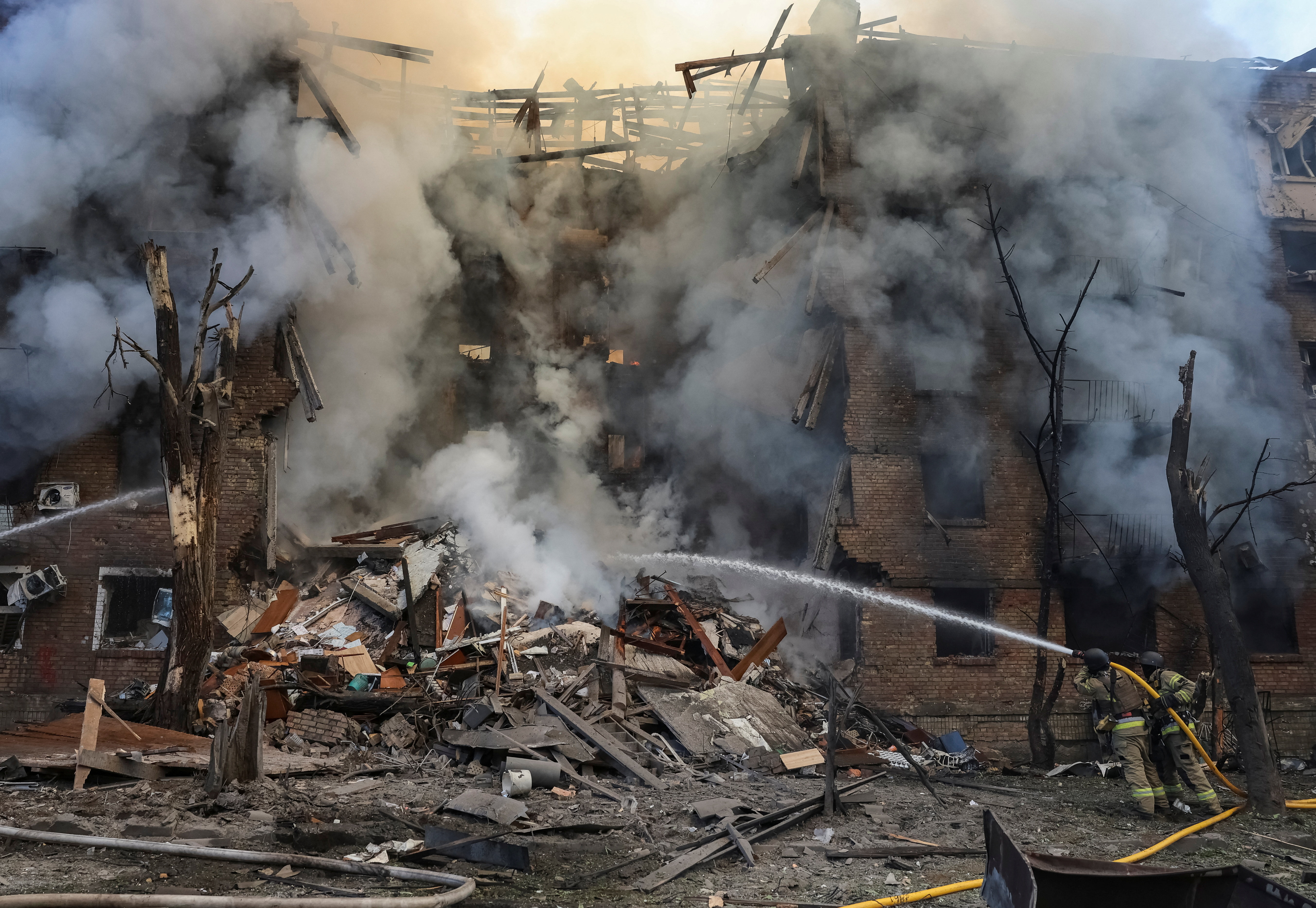 Firefighters work at the site of an apartment building destroyed by a Russian missile and drone strike