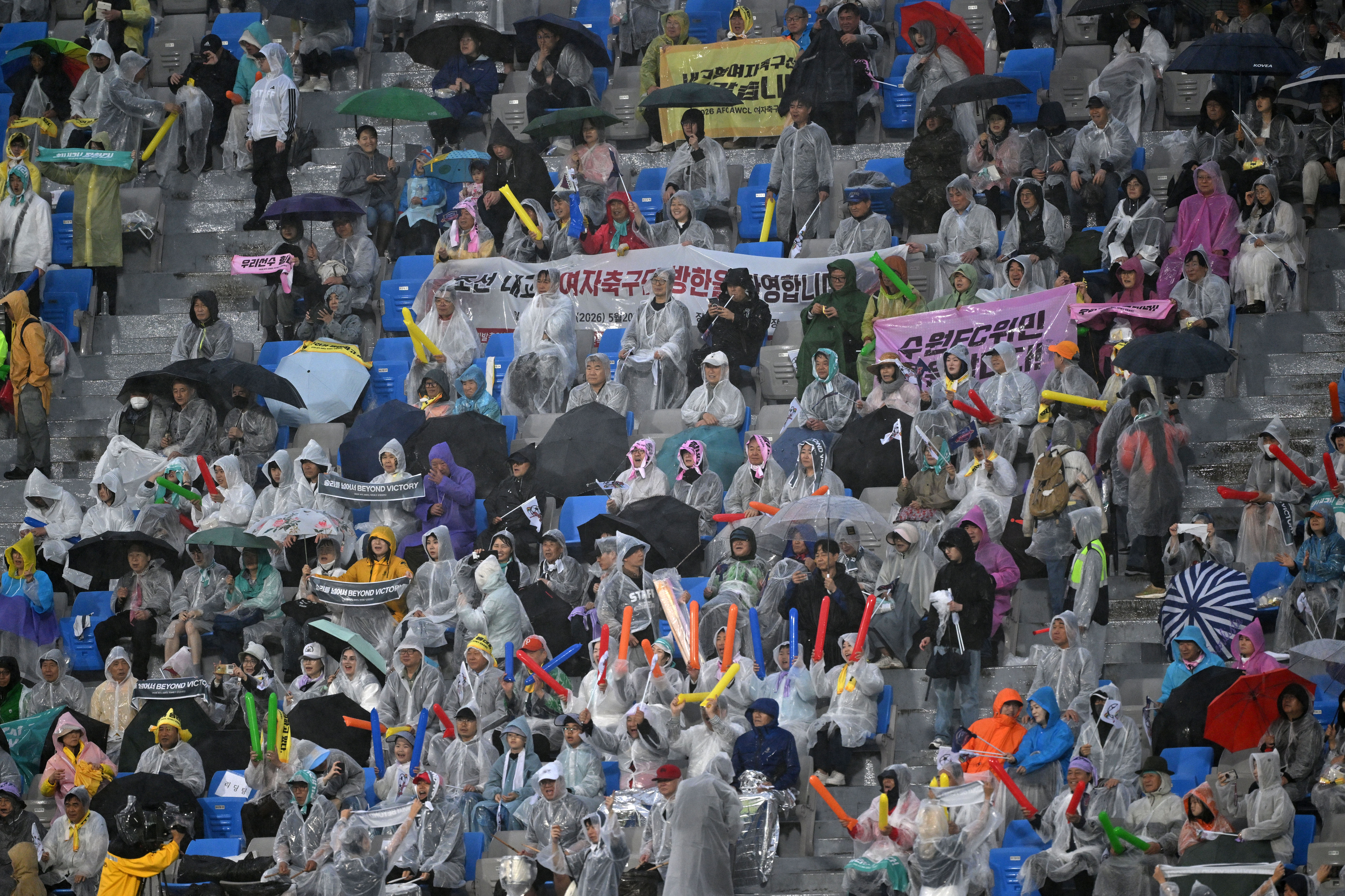 South Korean supporters cheer during the AFC Women's Champions League semi-final football match between North Korea's Naegohyang Women's FC and South Korea's Suwon FC Women in Suwon on May 20, 2026. (Photo by JUNG YEON-JE / AFP)