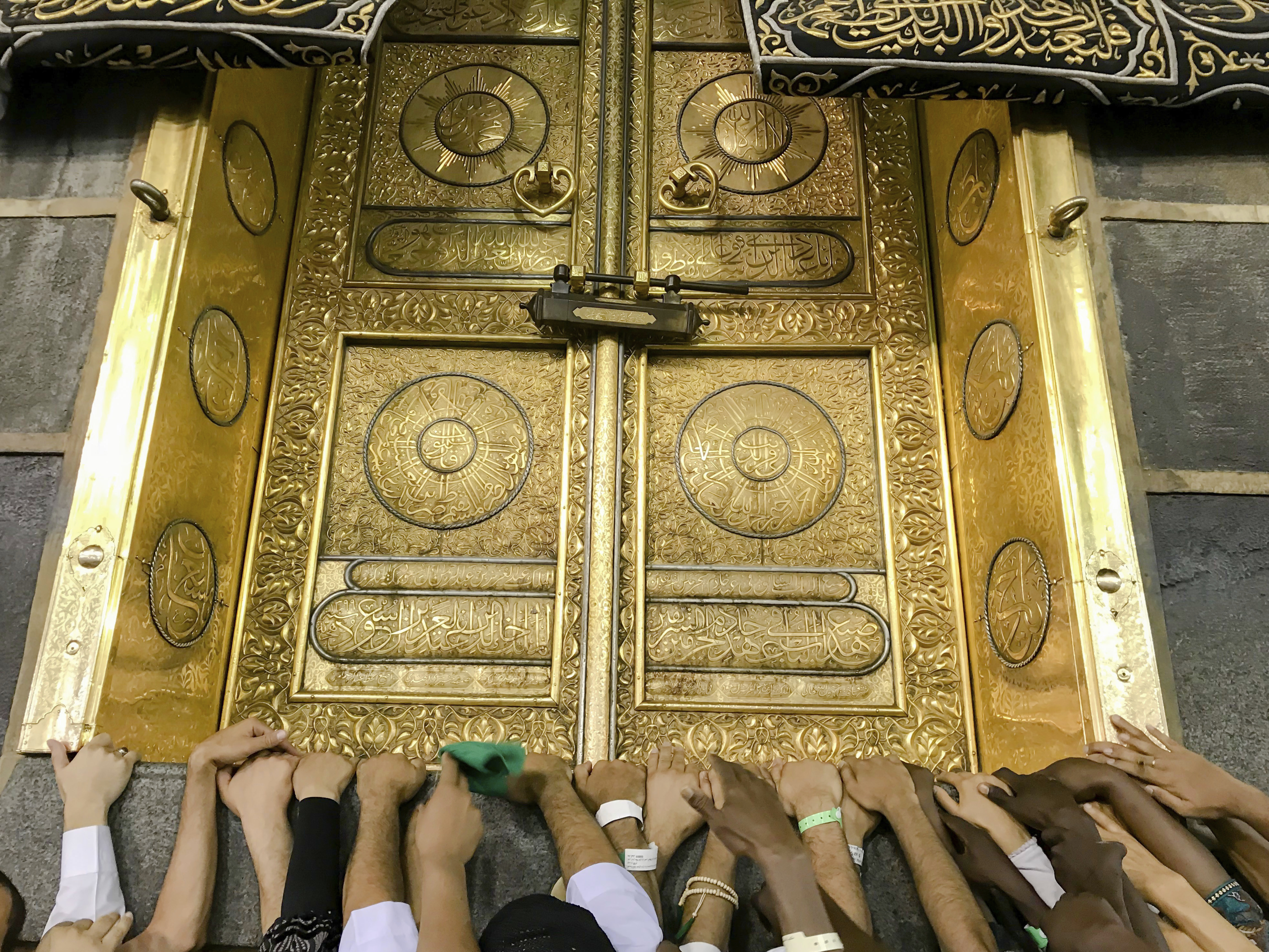 Muslim pilgrims touch the golden door of the Kaaba, as they pray ahead of the annual Hajj pilgrimage in the Muslim holy city of Mecca, Saudi Arabia, August 17, 2018