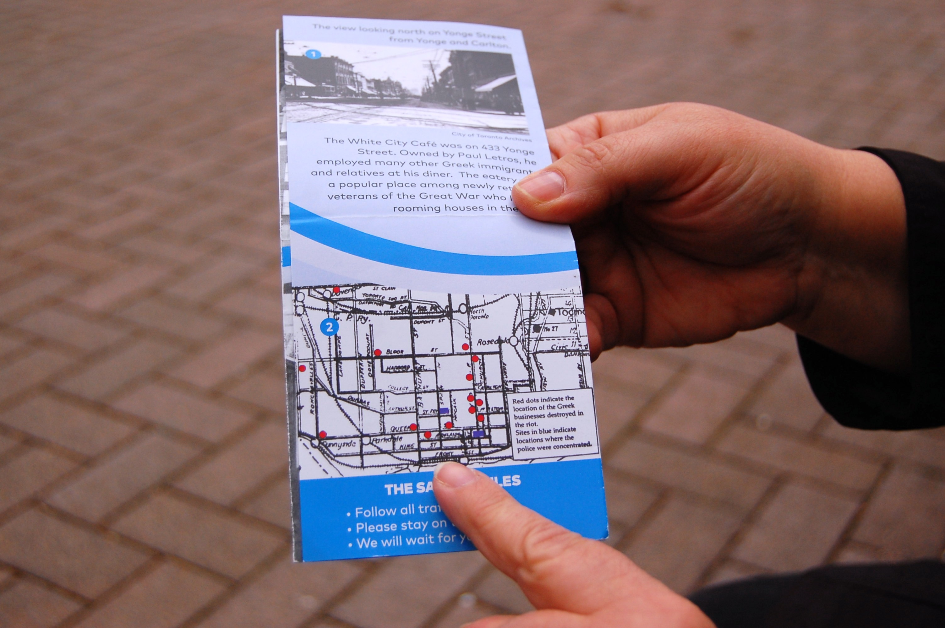 Sandra Gionas of the Hellenic Heritage Foundation holds a pamphlet about the anti-Greek riots in Toronto, Canada, in 1918