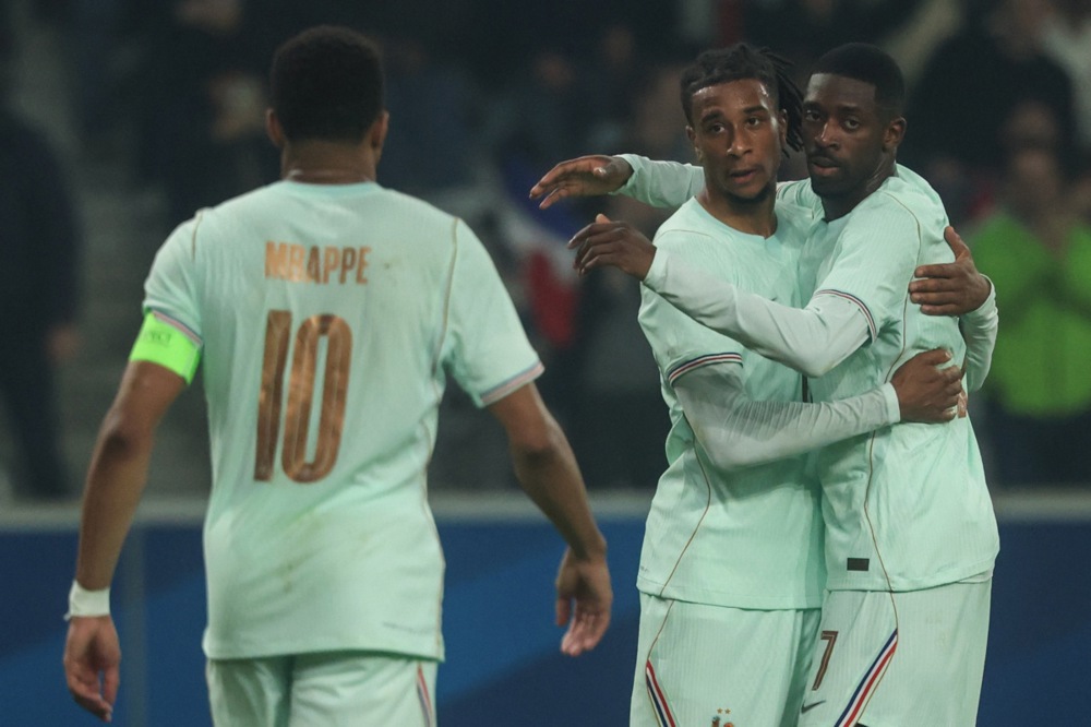 Michael Olise (C) of France celebrates with his teammates Kylian Mbappe (L) and Ousmane Dembele.