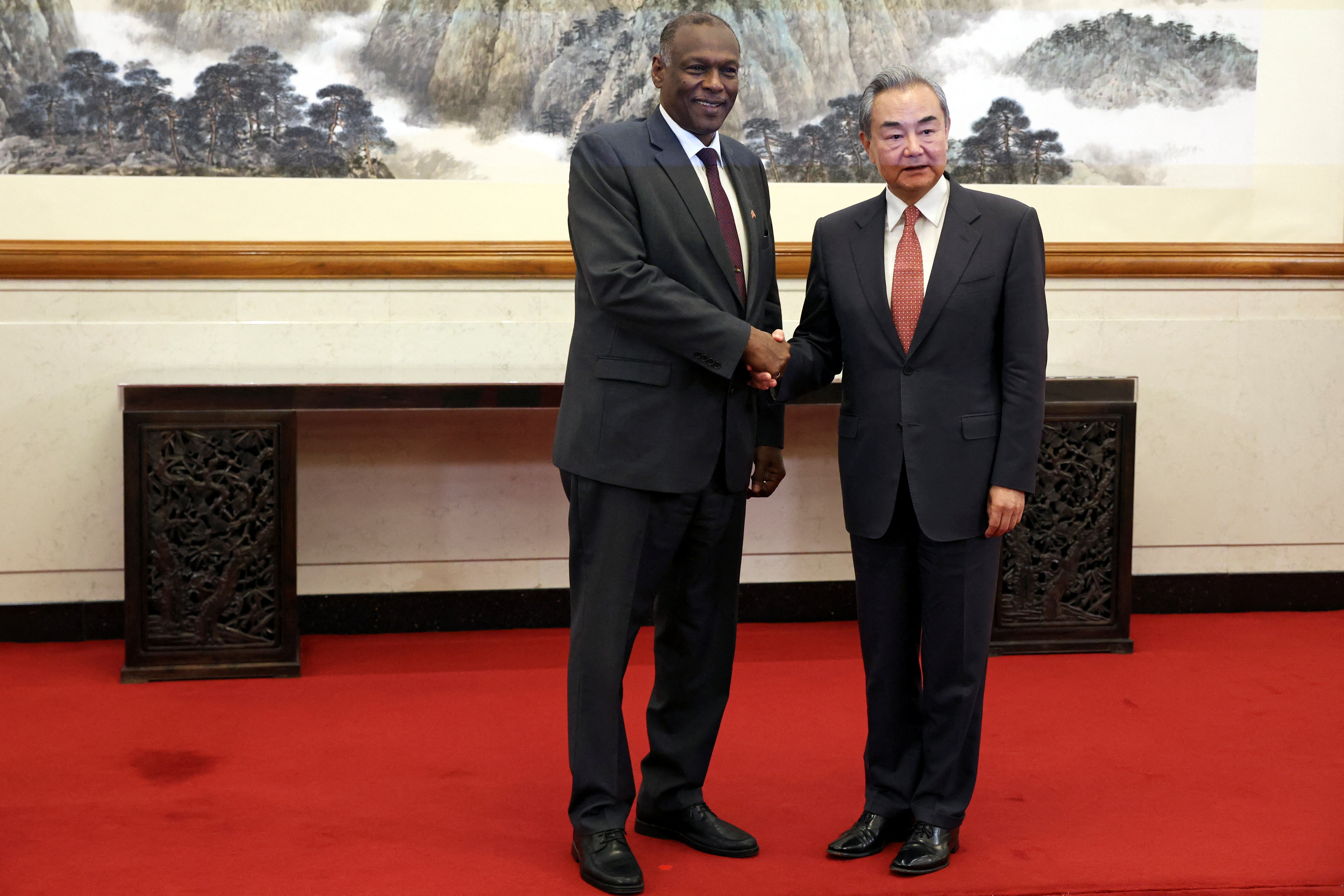 Wang Yi and Omar Seddik shake hands before a meeting at a state guesthouse in Beijing