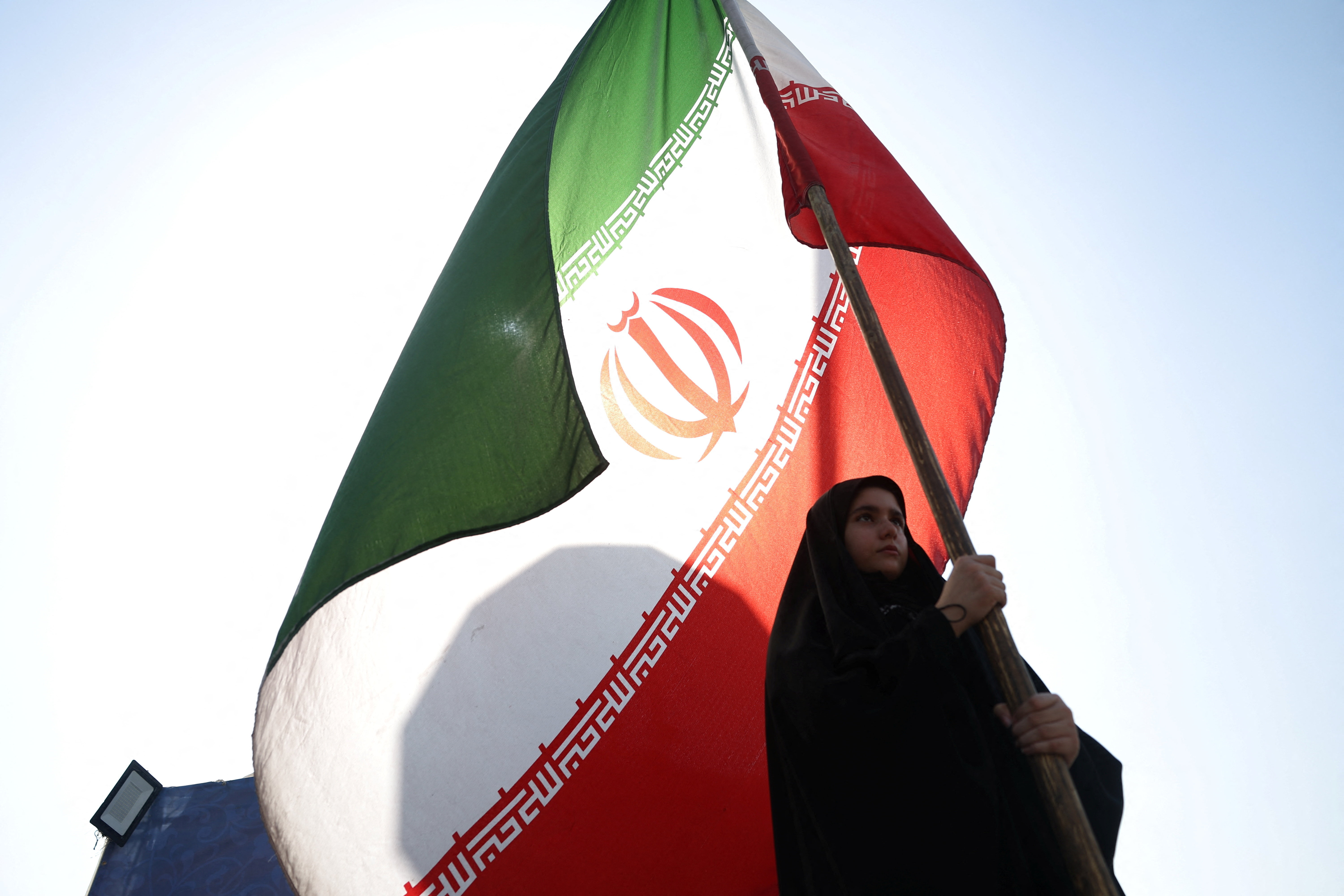 A woman holds an Iranian flag on a street in Tehran, Iran, June 10, 2026.