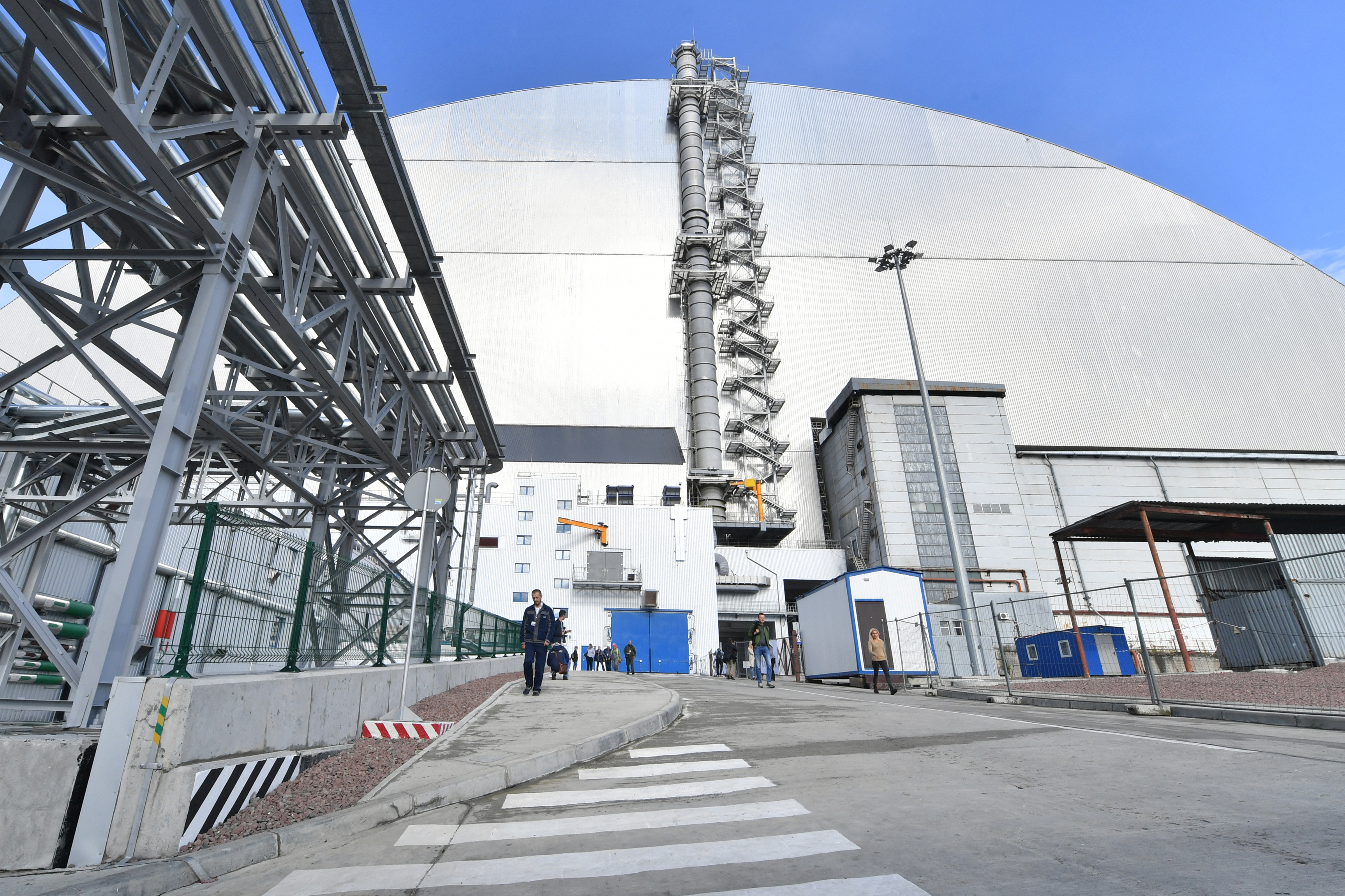 the New Safe Confinement (NSC) new metal dome designed and built by French consortium Novarka encasing the destroyed reactor at Chernobyl plant on July 10, 2019, in Chernobyl. Ukraine and its European partners on July 10 formally inaugurated a new metal dome encasing the destroyed reactor at the infamous Chernobyl plant, wrapping up a two-decade effort. Branded as the world's largest moveable metal structure, the so-called New Safe Confinement seals the remains of the fourth reactor at the nuclear plant that was the site of the massive Chernobyl disaster in 1986. (Photo by SERGEI SUPINSKY / AFP)