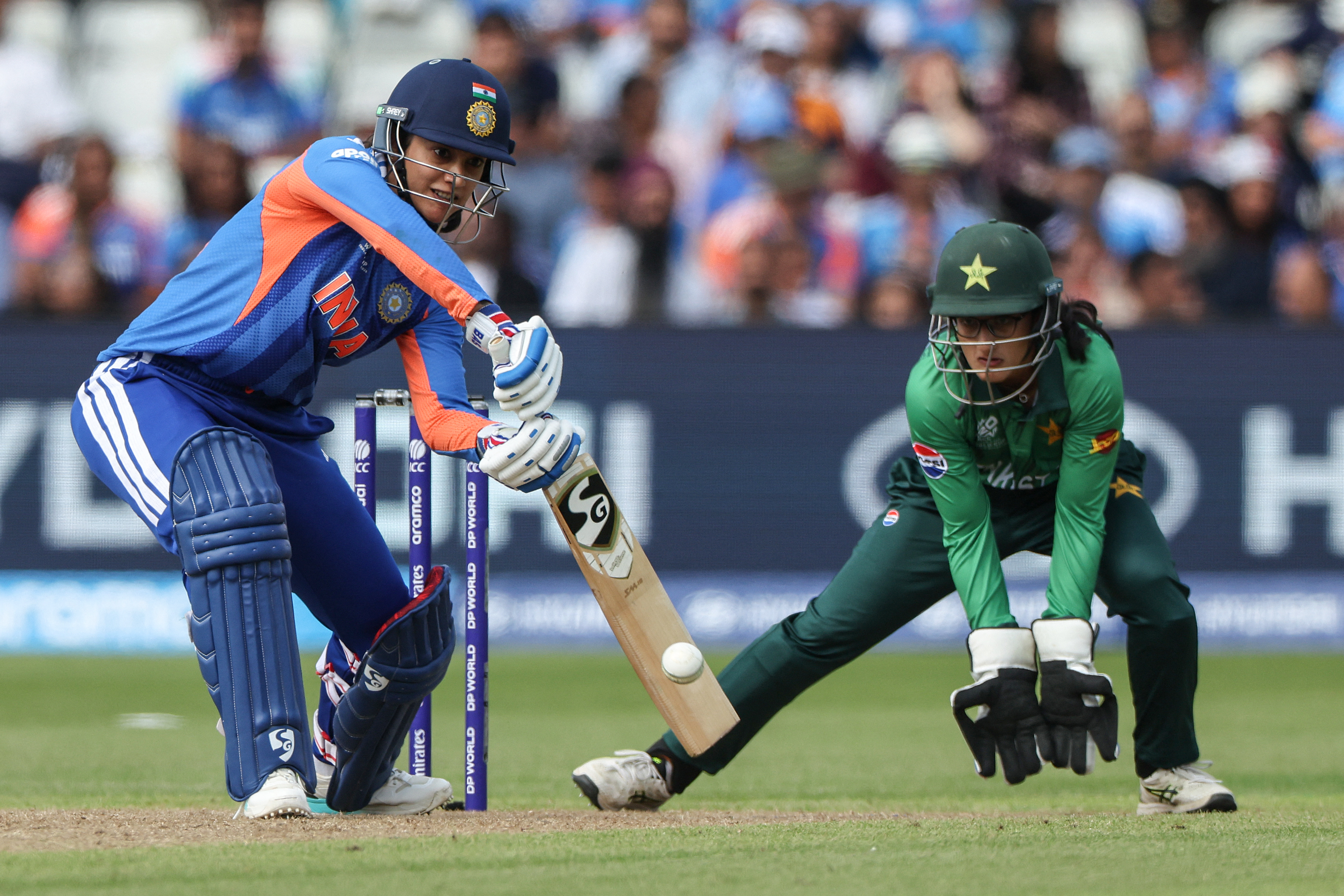 India's Smriti Mandhana (L) plays a shot during the ICC Women's T20 cricket World Cup 2026 Group A stage, Match 6 match between the India and Pakistan at Edgbaston cricket ground in Birmingham, central England on June 14, 2026. (Photo by Darren Staples / AFP)