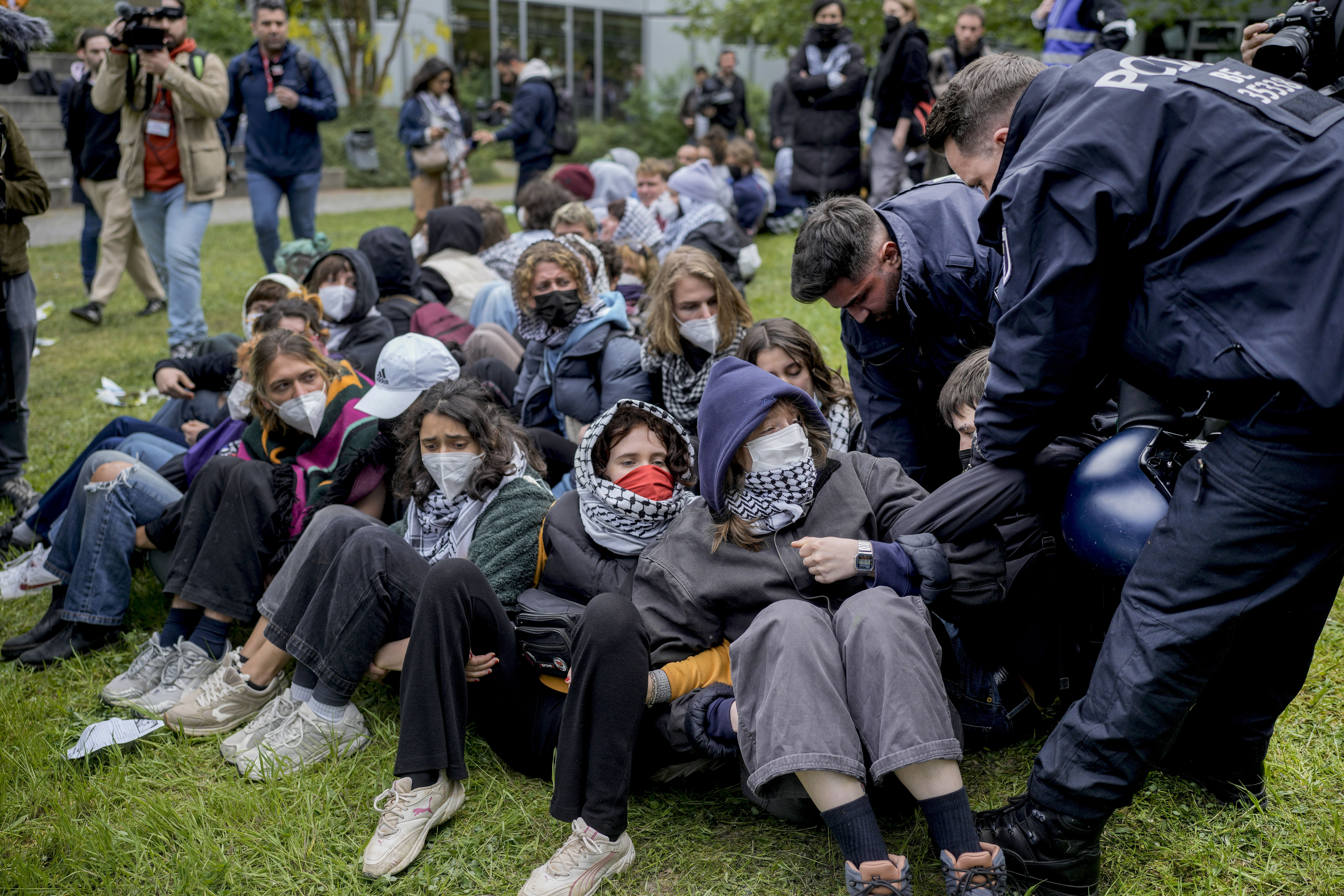 A man is carried away by police officers during a pro-Palestinians demonstration by the group "Student Coalition Berlin" in the theater courtyard of the 'Freie Universität Berlin' university in Berlin