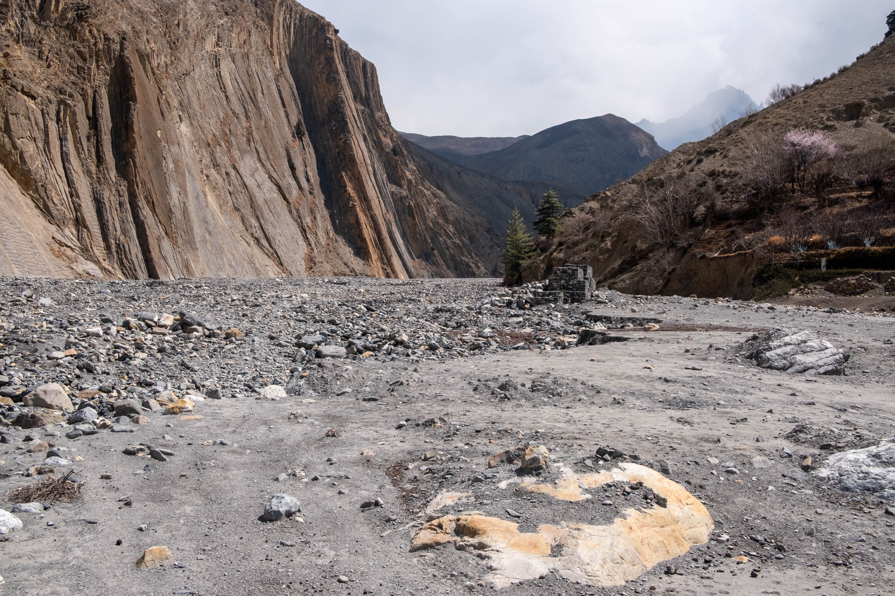 A white rock marks where the fields used to extend to in the village of Lubra. It now sits in the middle of the riverbed, owing to floods [Eileen McDougall/Al Jazeera]