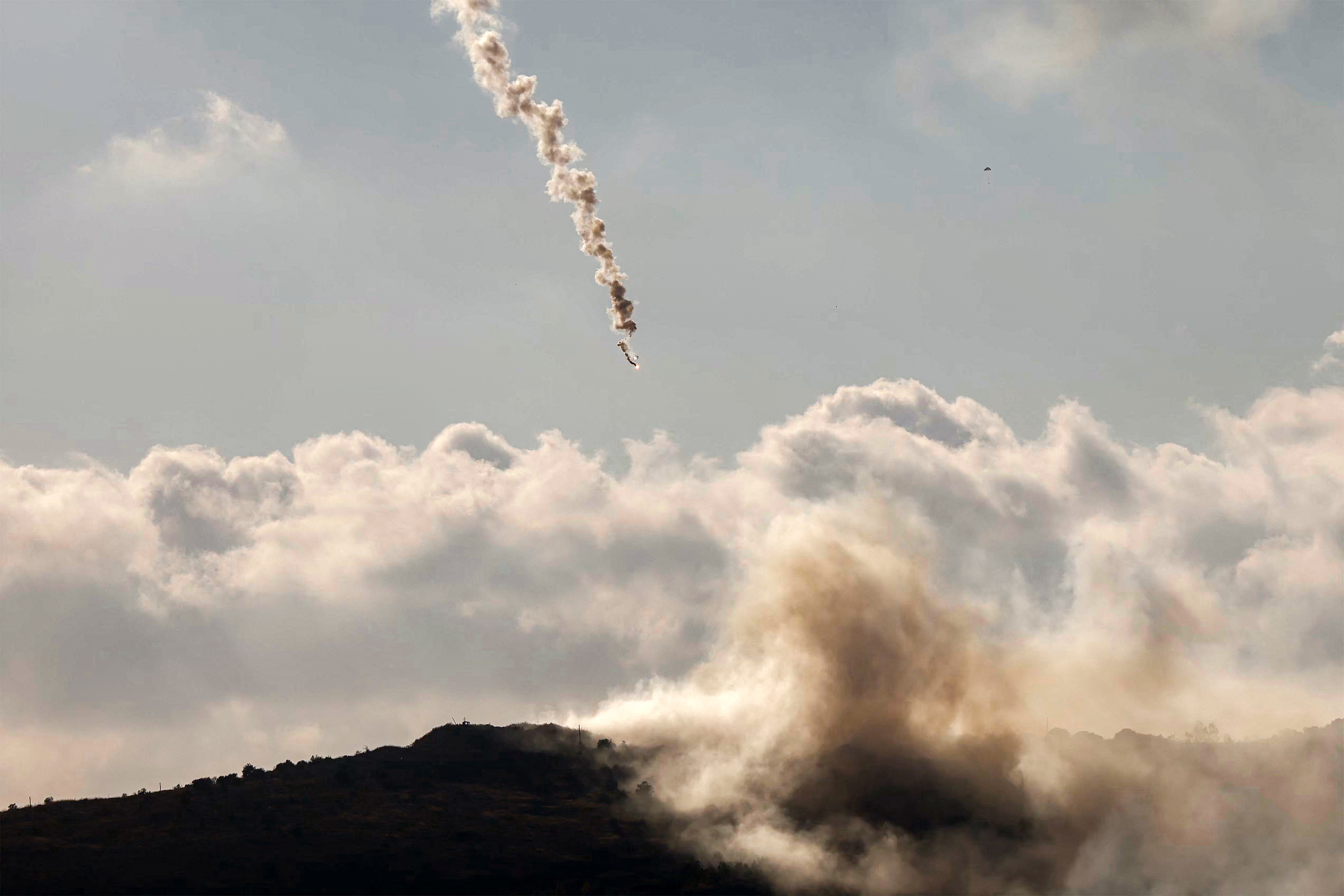TOPSHOT - A flare fired by the Israeli military lands over the highlands of the area of Ali al-Taher as seen from nearby Marjayoun (Marjeyoun) in southern Lebanon on June 14, 2026.