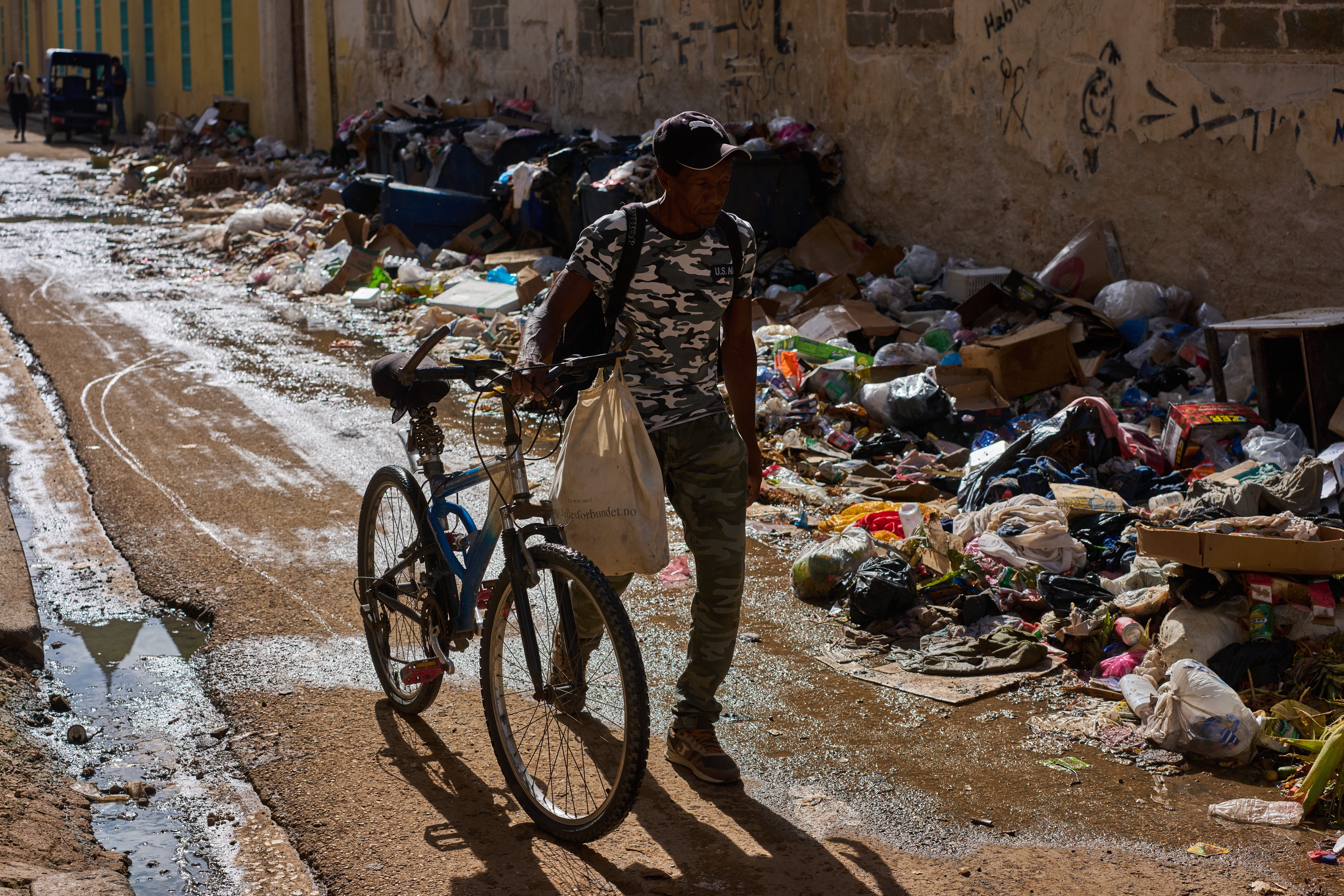 A man pushes his bicycle along a trash-strewn street in Havana, Cuba, Tuesday, June 9, 2026. (AP Photo/Ramon Espinosa)