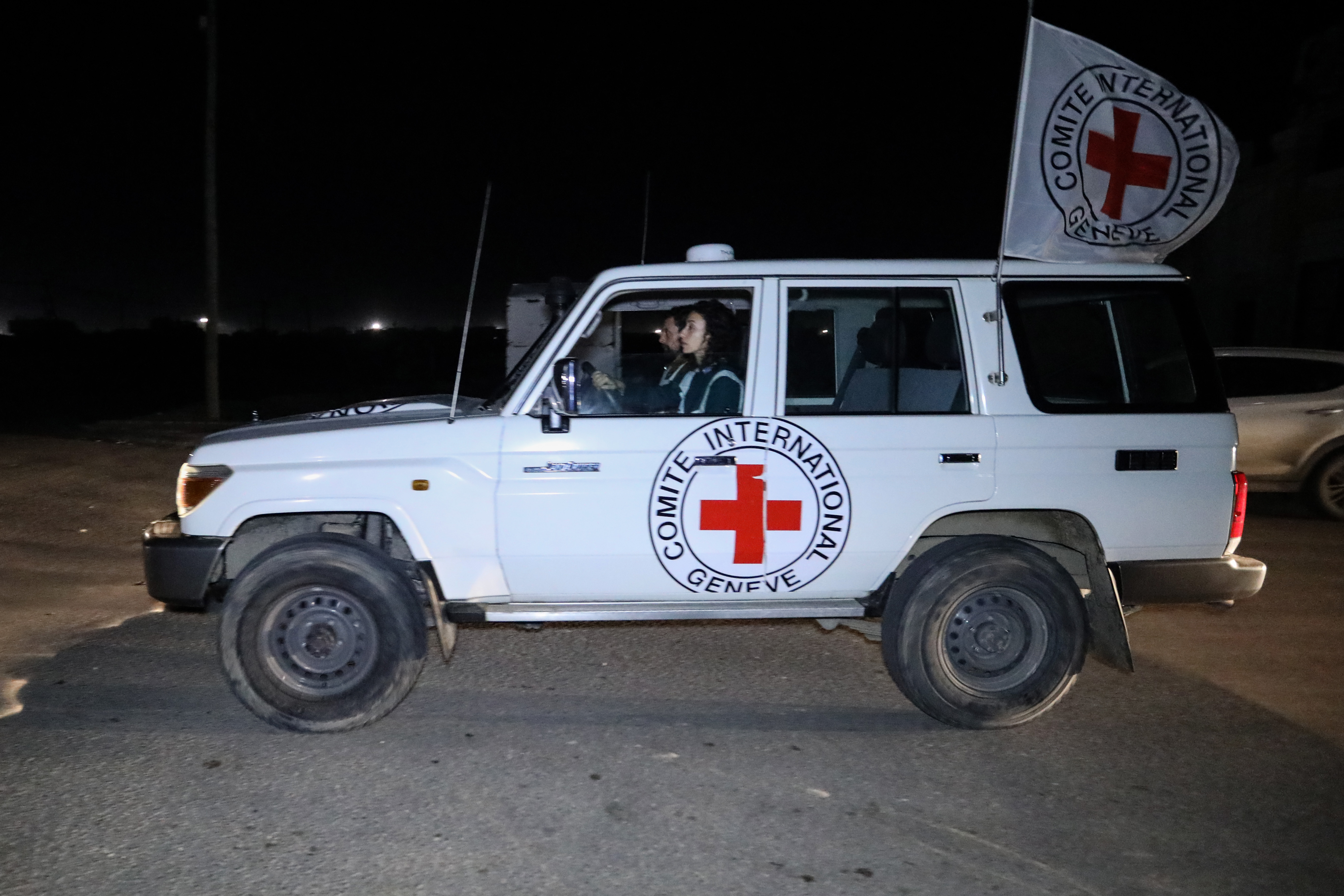 RAFAH, GAZA - NOVEMBER 30: Hostages are transported in International Committee of the Red Cross vehicles from the Gaza Strip through the Rafah land crossing on November 30, 2023 in Rafah, Gaza. Israel and Hamas agreed to a further extension to a truce that has lasted nearly a week, which promised the release of more Israeli hostages held in Gaza, as well as the release of Palestinian prisoners held in Israeli jails. (Photo by Ahmad Hasaballah/Getty Images)