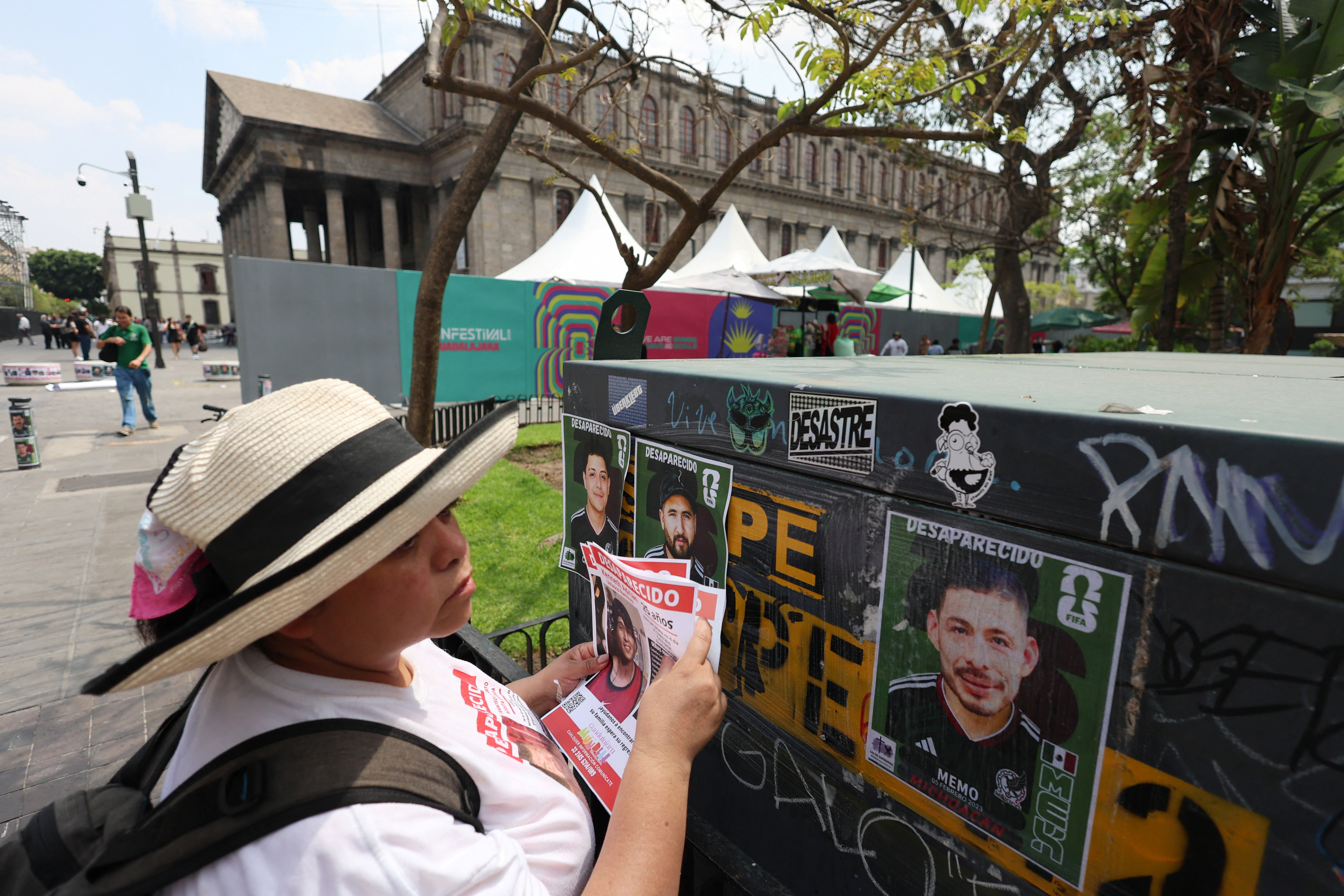 A member of the Colectivo Luz de Esperanza de Jalisco collective holds missing-person flyers near pasted signs featuring images of their loved ones who remain missing, displayed in a World Cup-style format, as part of the “Missing Persons World Cup Album" campaign to raise awareness of disappearances ahead of the 2026 FIFA World Cup, in Guadalajara, Mexico, May 31, 2026. REUTERS/Michelle Freyria TPX IMAGES OF THE DAY
