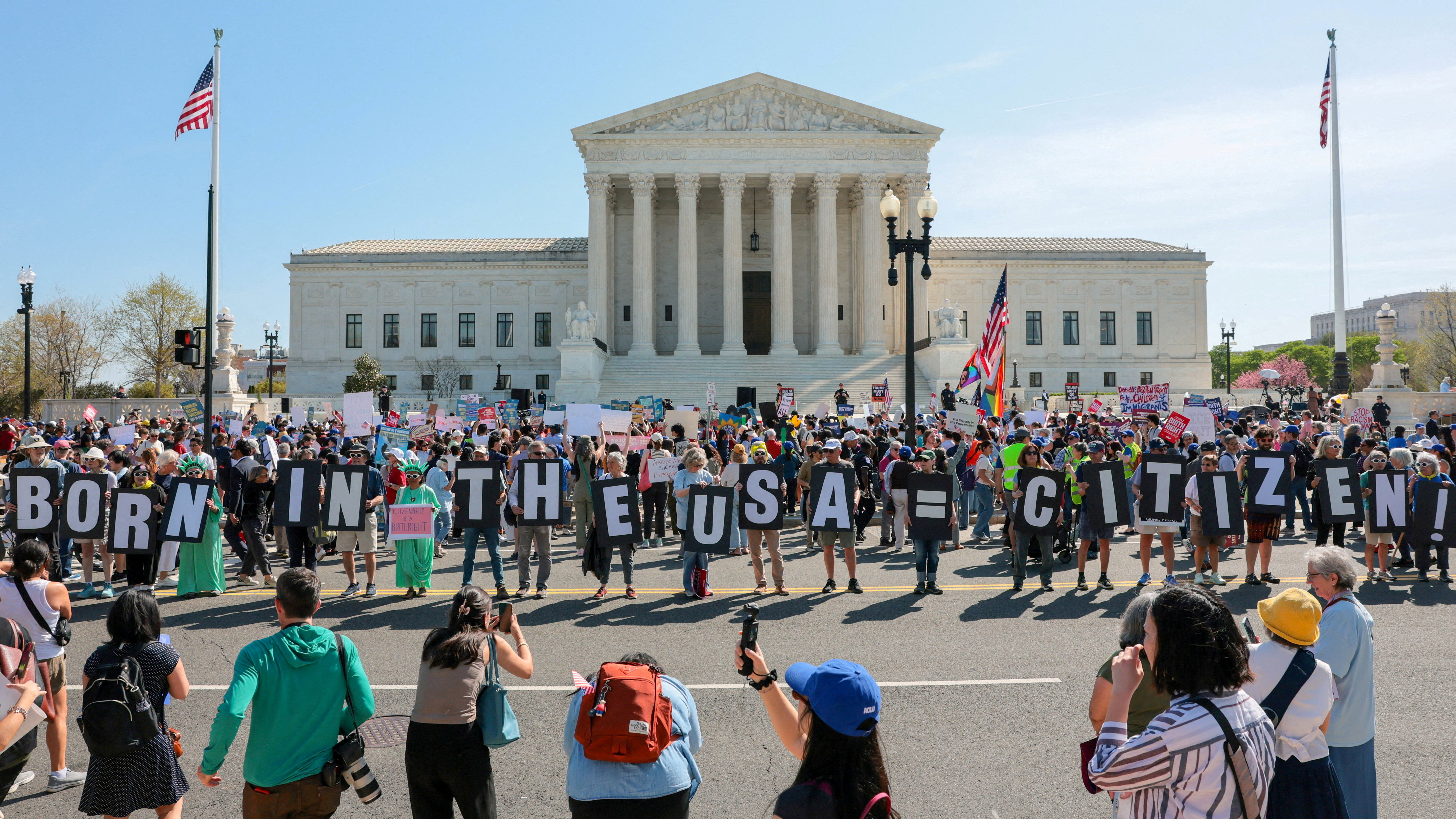 FILE PHOTO: Demonstrators hold letters making up the slogan "Born in the USA = citizen!" outside the U.S. Supreme Court building as the court hears oral arguments on the legality of the Trump administration's effort to limit birthright citizenship for the children of immigrants, in Washington, D.C., U.S., April 1, 2026. REUTERS/Kylie Cooper/File Photo
