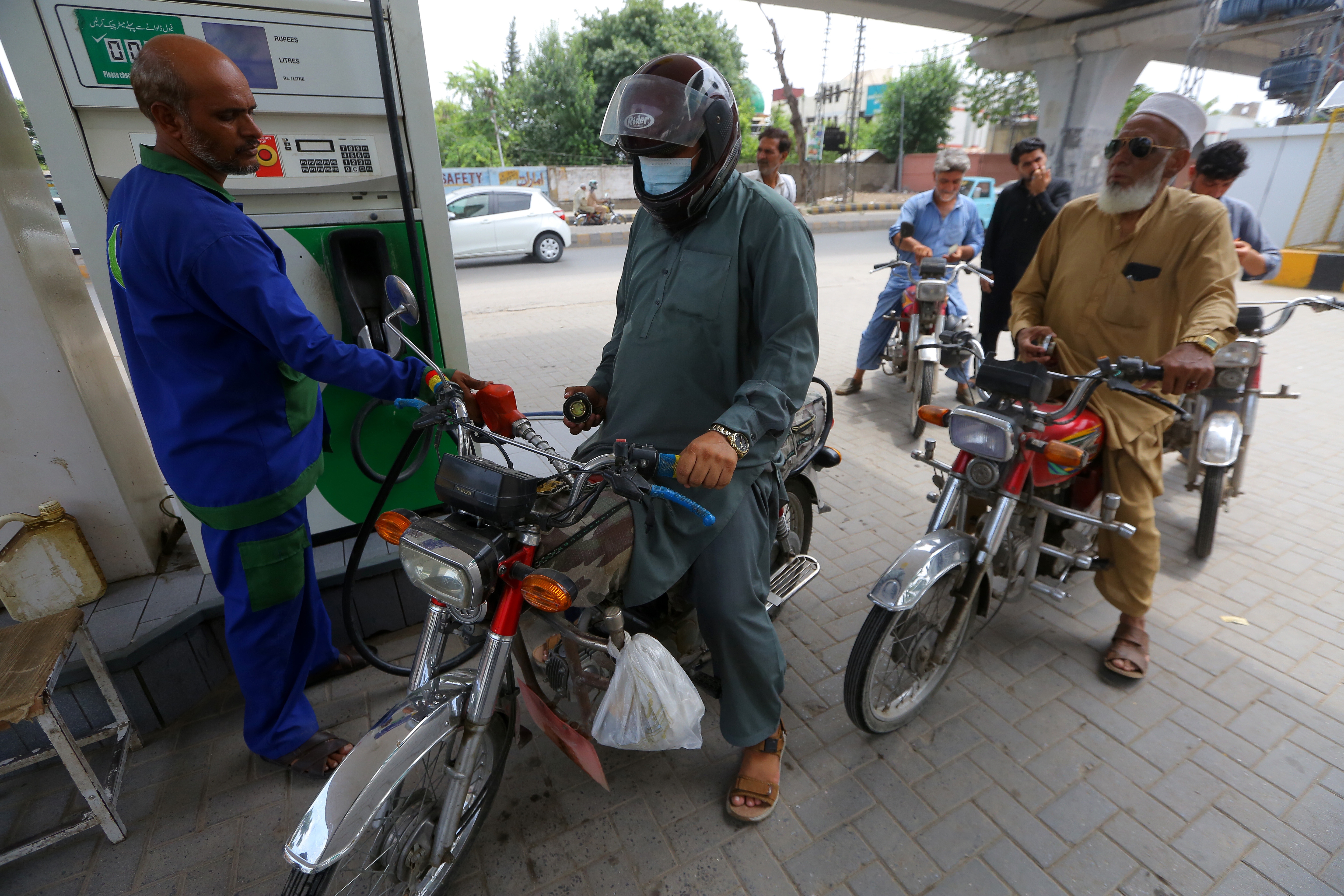 A worker fills the fuel tank of a customer's motorbike at a petrol station in Peshawar, Pakistan, 11 July 2026. Pakistan increased retail petroleum prices by more than 13 Pakistani rupees (about USD 0.047) per liter, citing a sharp rise in global oil prices amid renewed US-Iran hostilities and tensions around the Strait of Hormuz. The revised fuel prices took effect