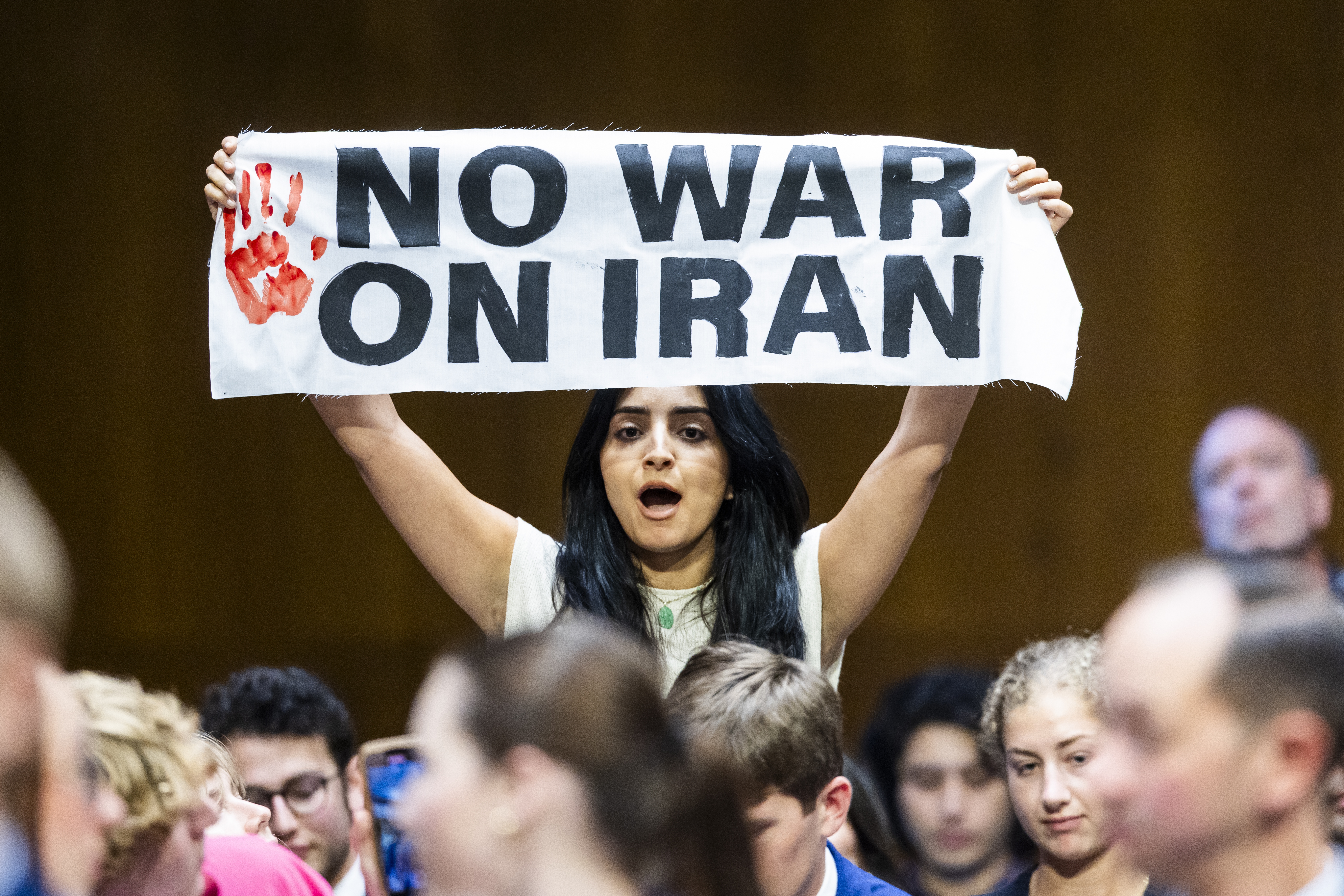 An antiwar protester holds a sign as US Secretary of Defense Pete Hegseth and Chairman of the Joint Chiefs General John Caine testify on the Defense Department’s budget before the Senate Committee on Appropriations in the Dirksen Senate Office Building in Washington, DC, on July 21, 2026