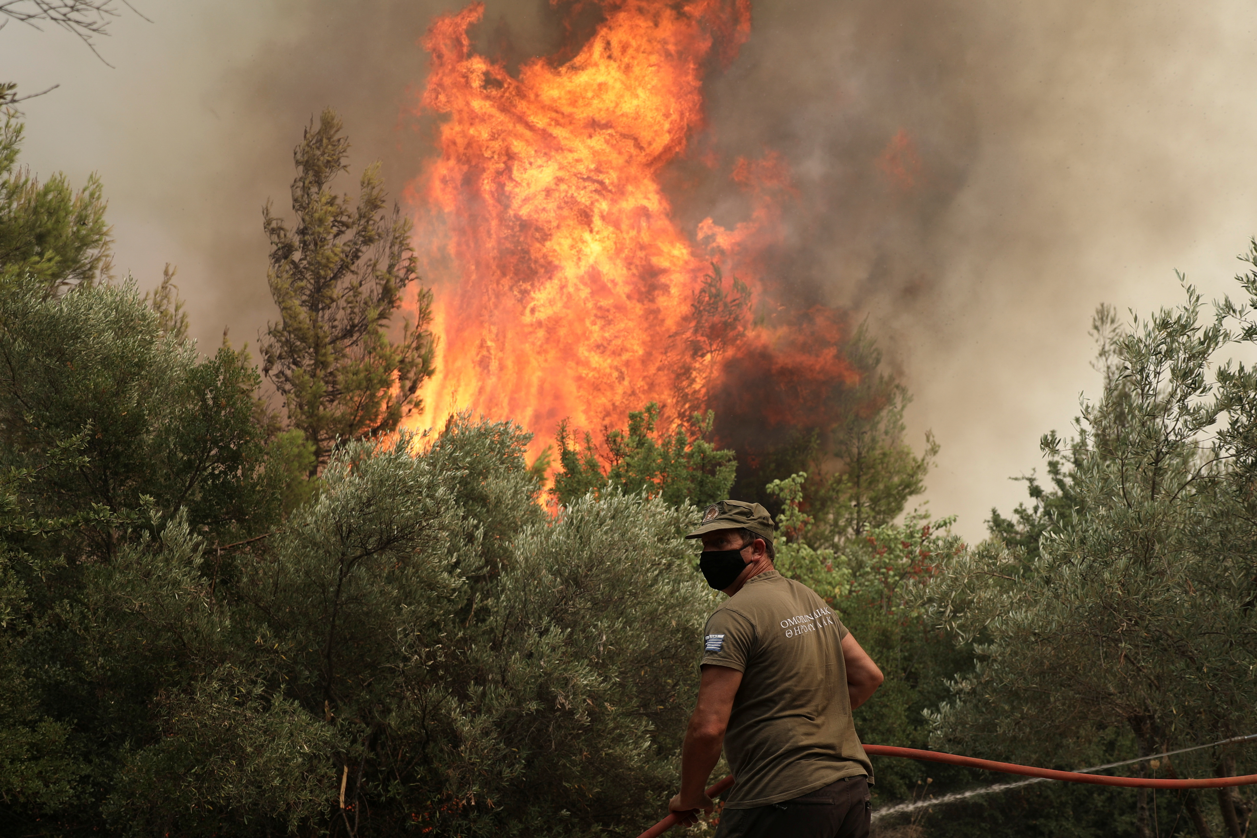 A firefighter tries to extinguish a fire in the village of Avgaria, on the island of Evia, Greece, August 10, 2021. REUTERS/Stelios Misinas
