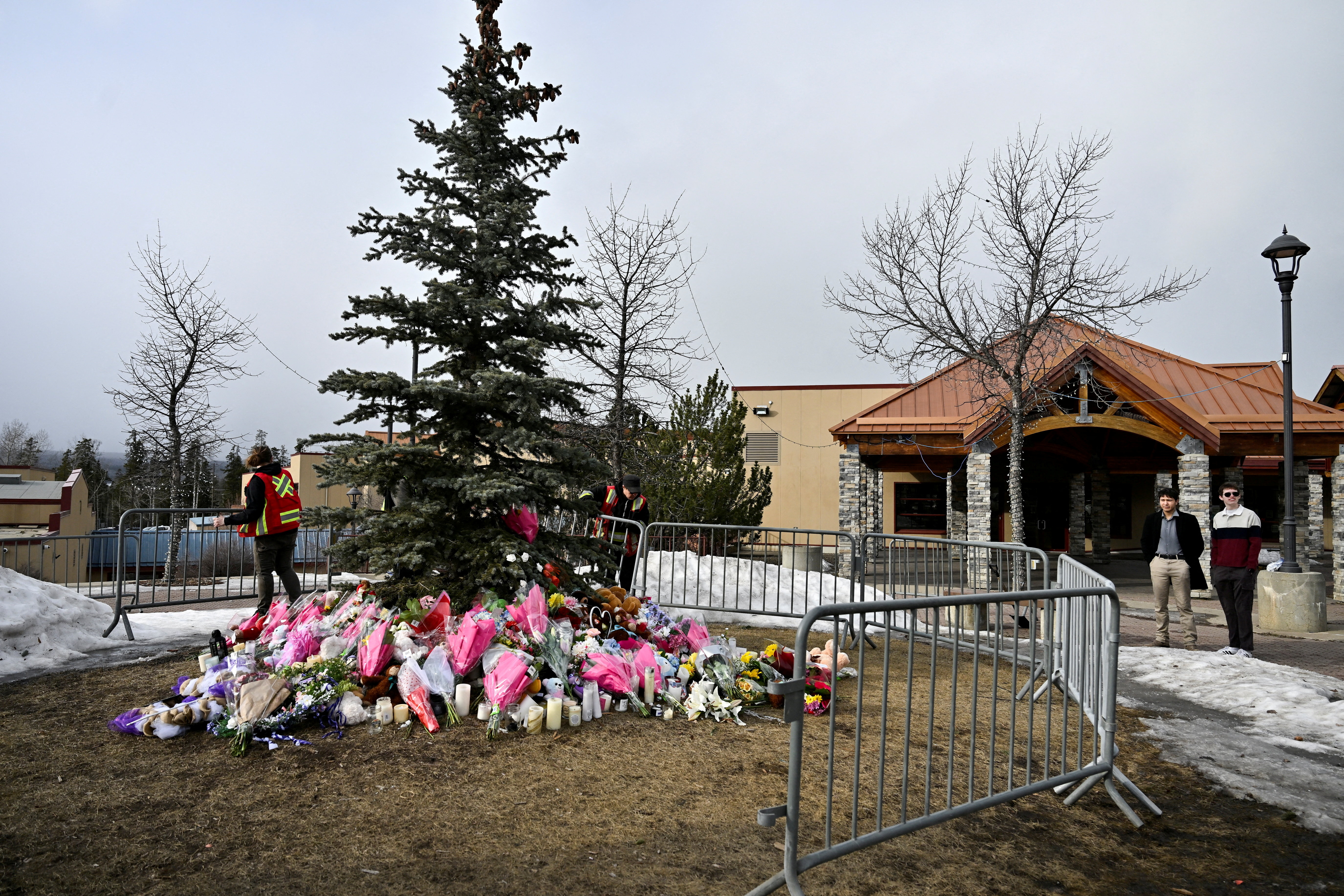 Workers install a fence around a makeshift memorial for the victims two days after a deadly mass shooting took place at a school in the town of Tumbler Ridge, British Columbia, Canada [FILE: Jennifer Gauthier/Reuters]