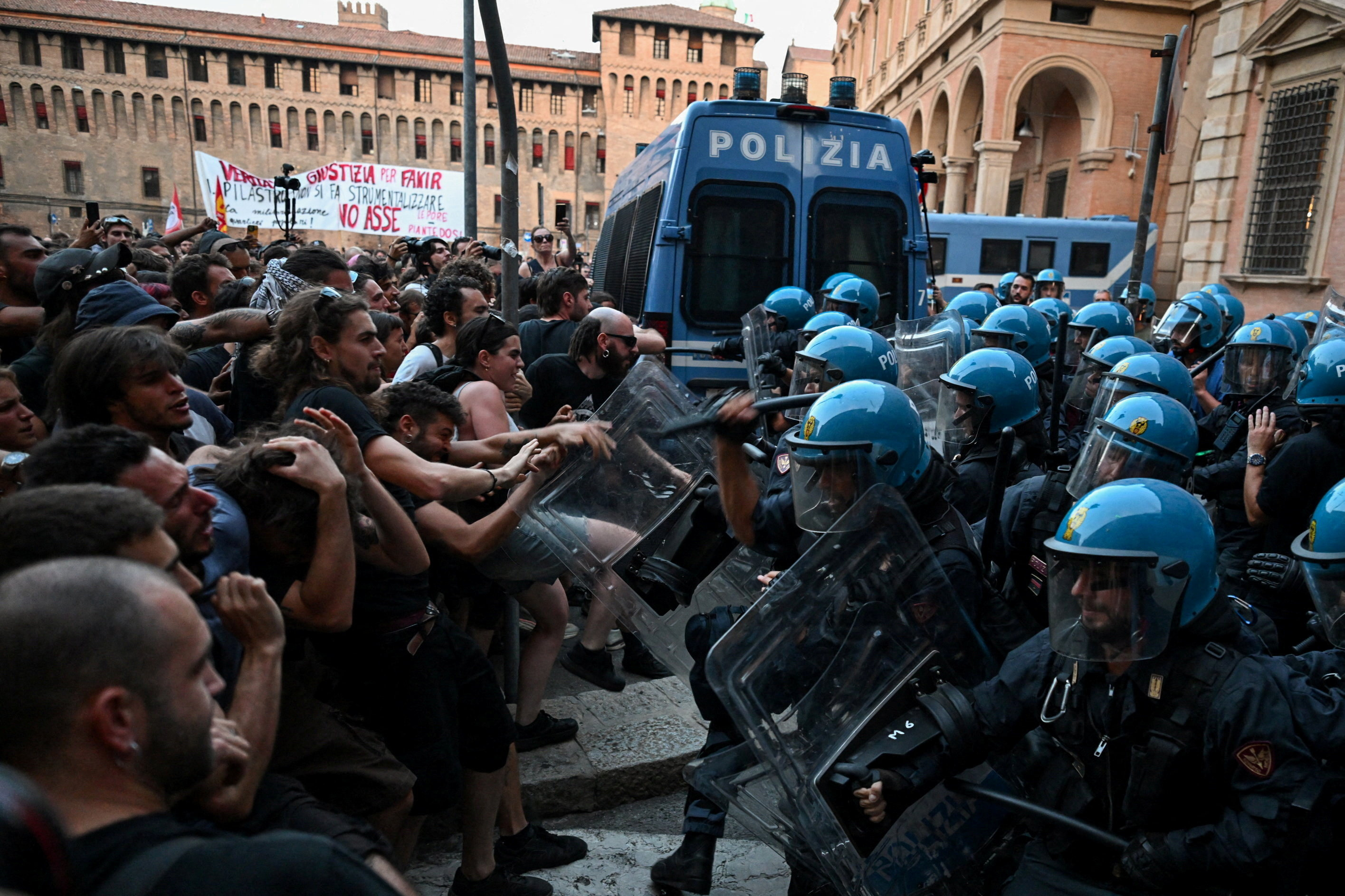 Protesters clash with riot police during a protest following the death of Abderrahim Fakir, in Bologna, Italy