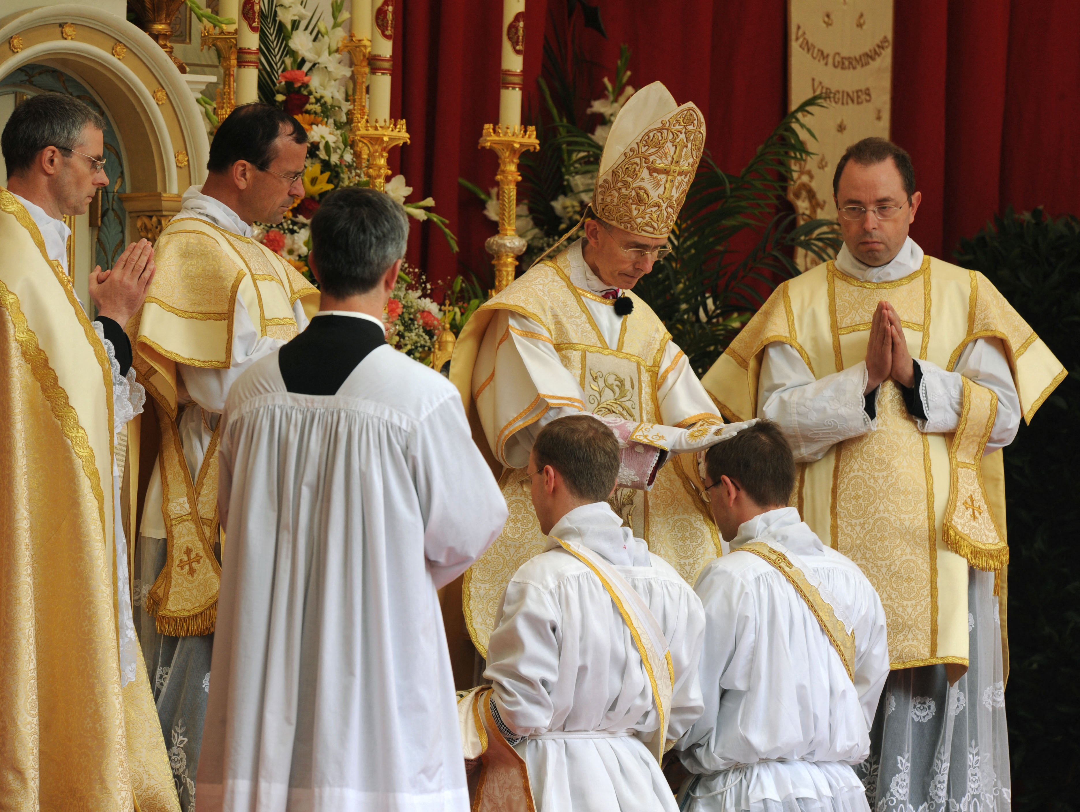 Priests lay their hands on the heads of the future priests during the ordination to the priesthood of the Society of St Pius X in Zaitzkofen, southern Germany