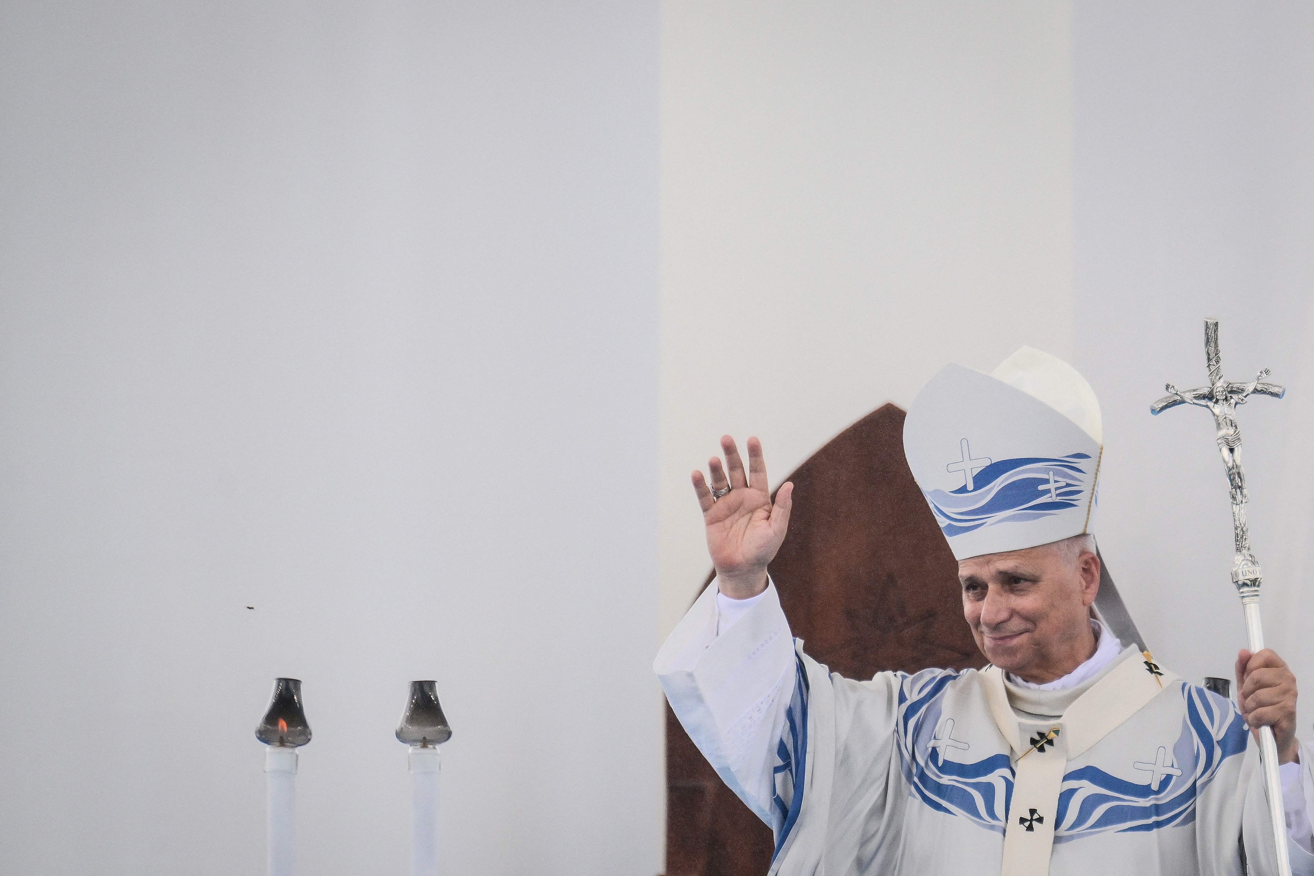 Pope Leo XIV waves as he celebrates Mass.