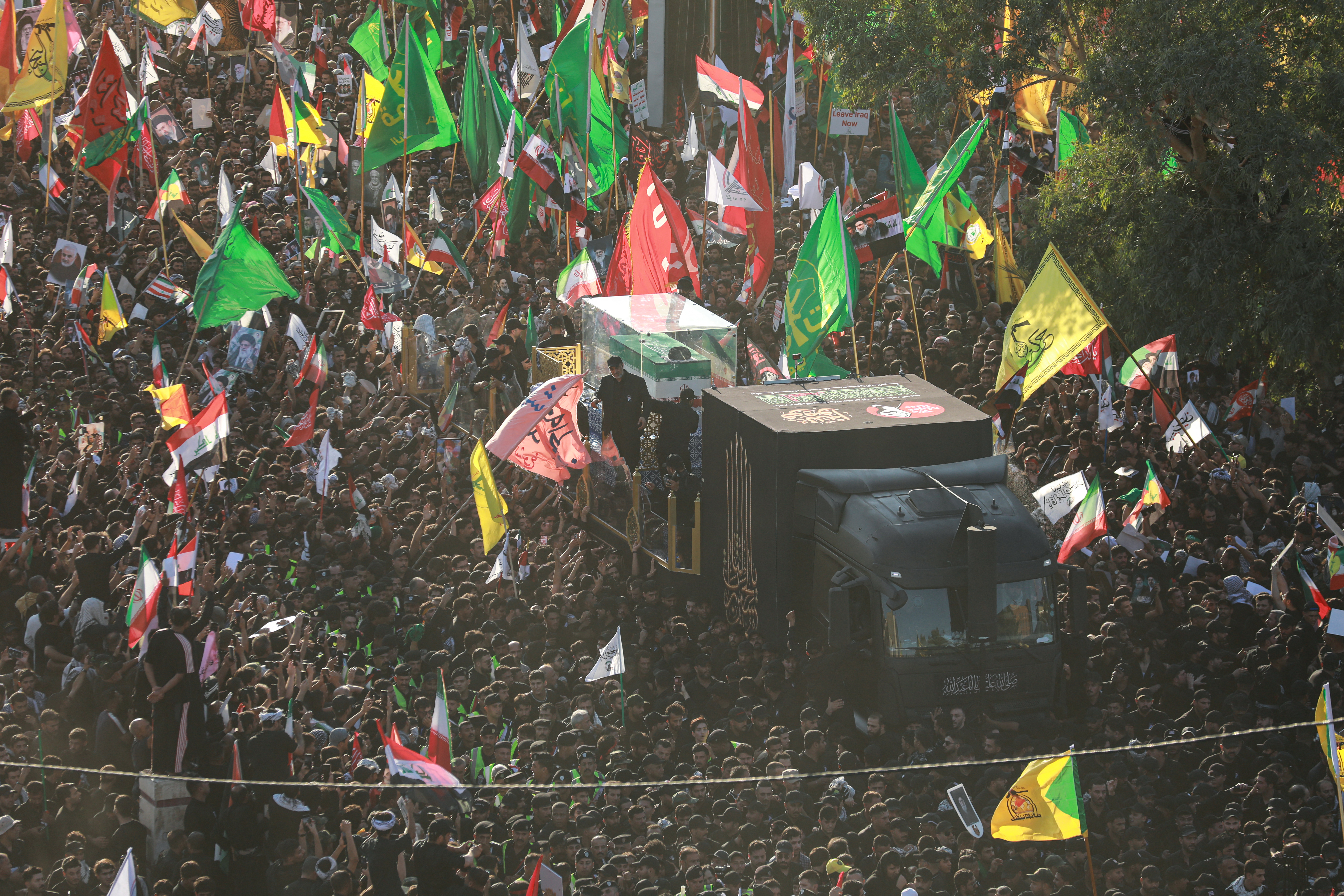 Mourners surround the convoy carrying the coffin of Ayatollah Ali Khamenei during a funeral procession in Najaf, Iraq