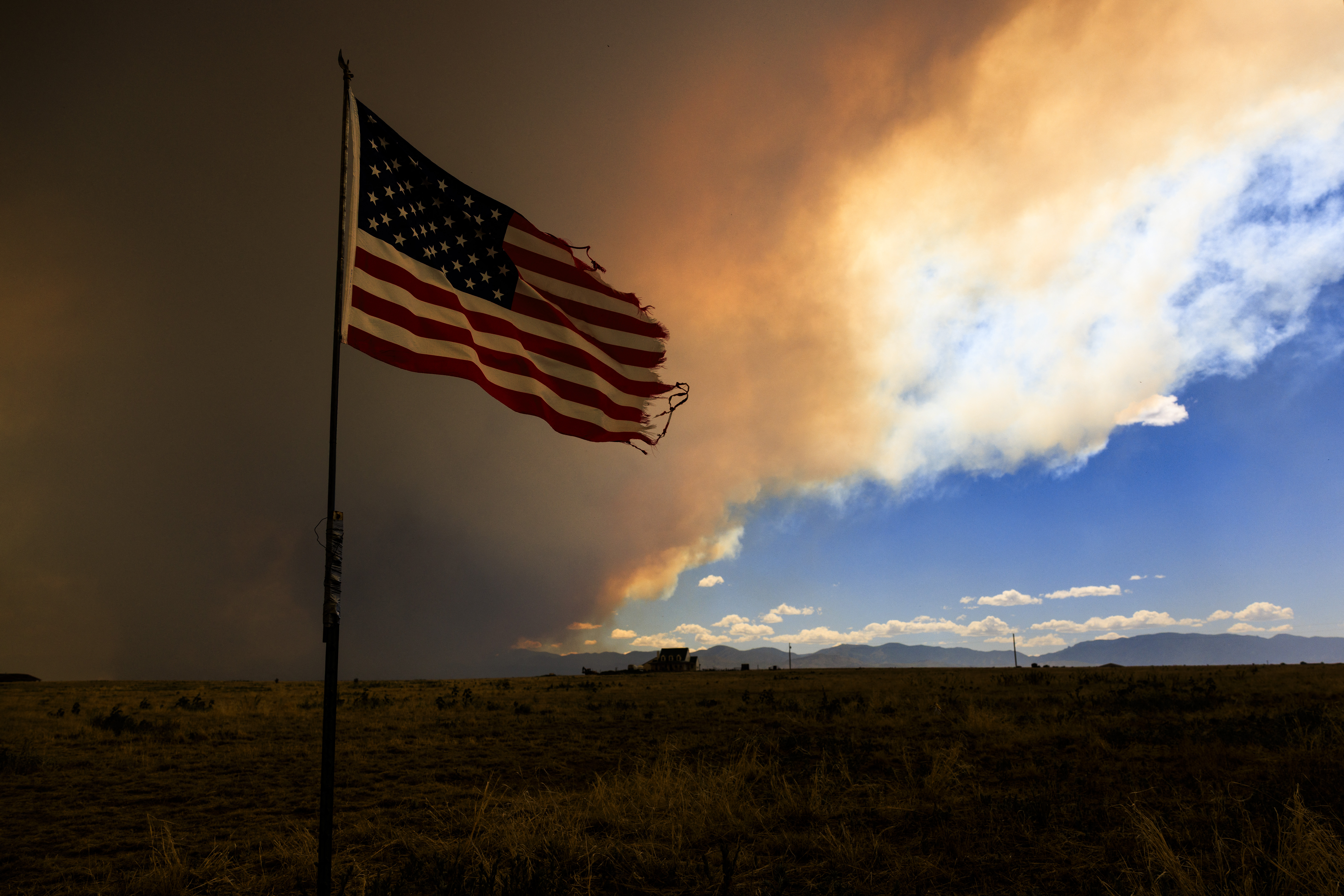 PUEBLO, COLORADO - JULY 1: Smoke from the Aspen Acres fire rises above a home on July 1, 2026 in Pueblo, Colorado. Over 35,000 acres and more than 100 structures have burned in the Aspen Acres fire, one of several blazes that are currently burning across the state after a warm and dry winter. Michael Ciaglo/Getty Images/AFP (Photo by Michael Ciaglo / GETTY IMAGES NORTH AMERICA / Getty Images via AFP)