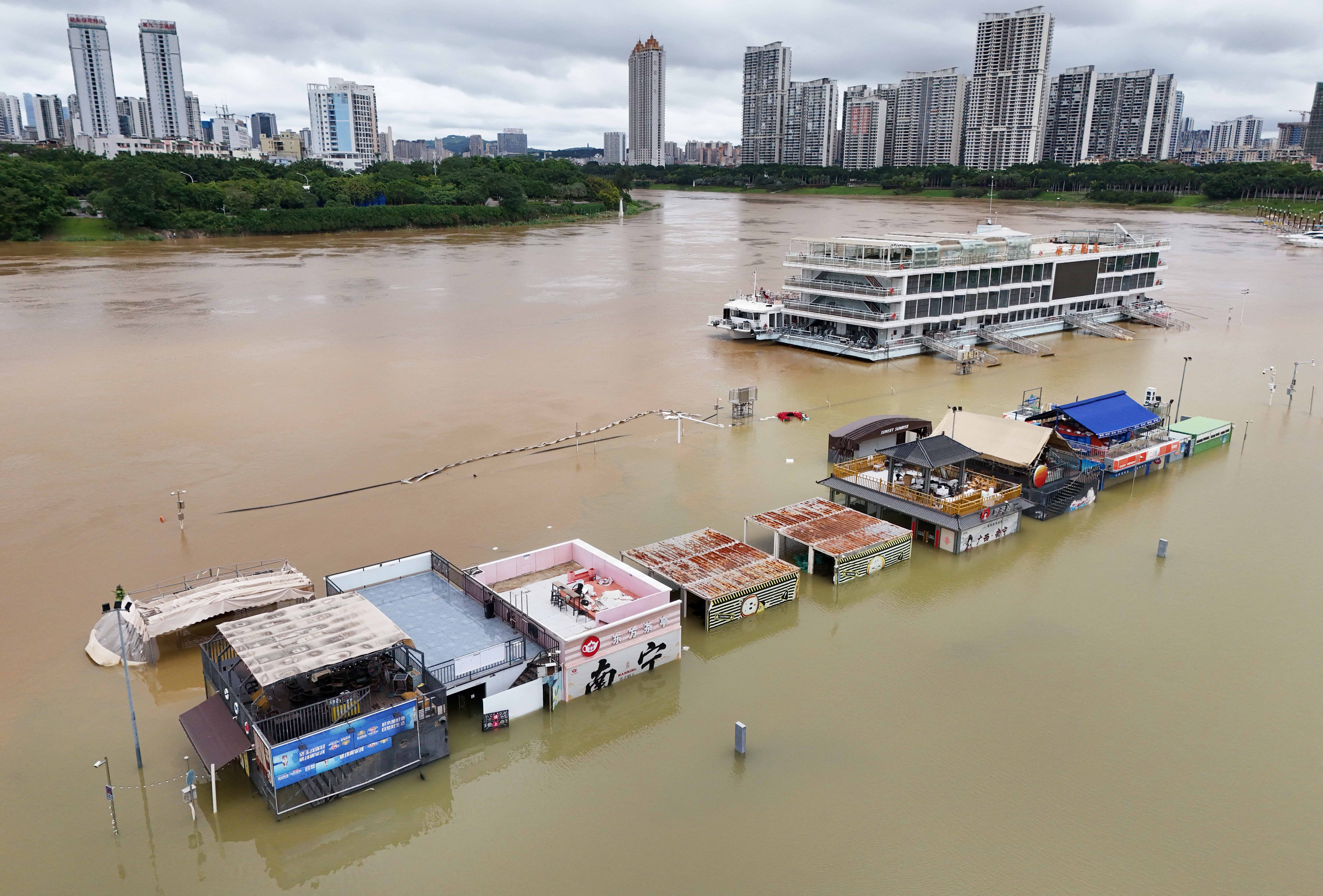 Flooded shops along a submerged riverside walk are seen by the overflowing Yongjiang river in Nanning, in China’s southern Guangxi region on July 7, 2026.