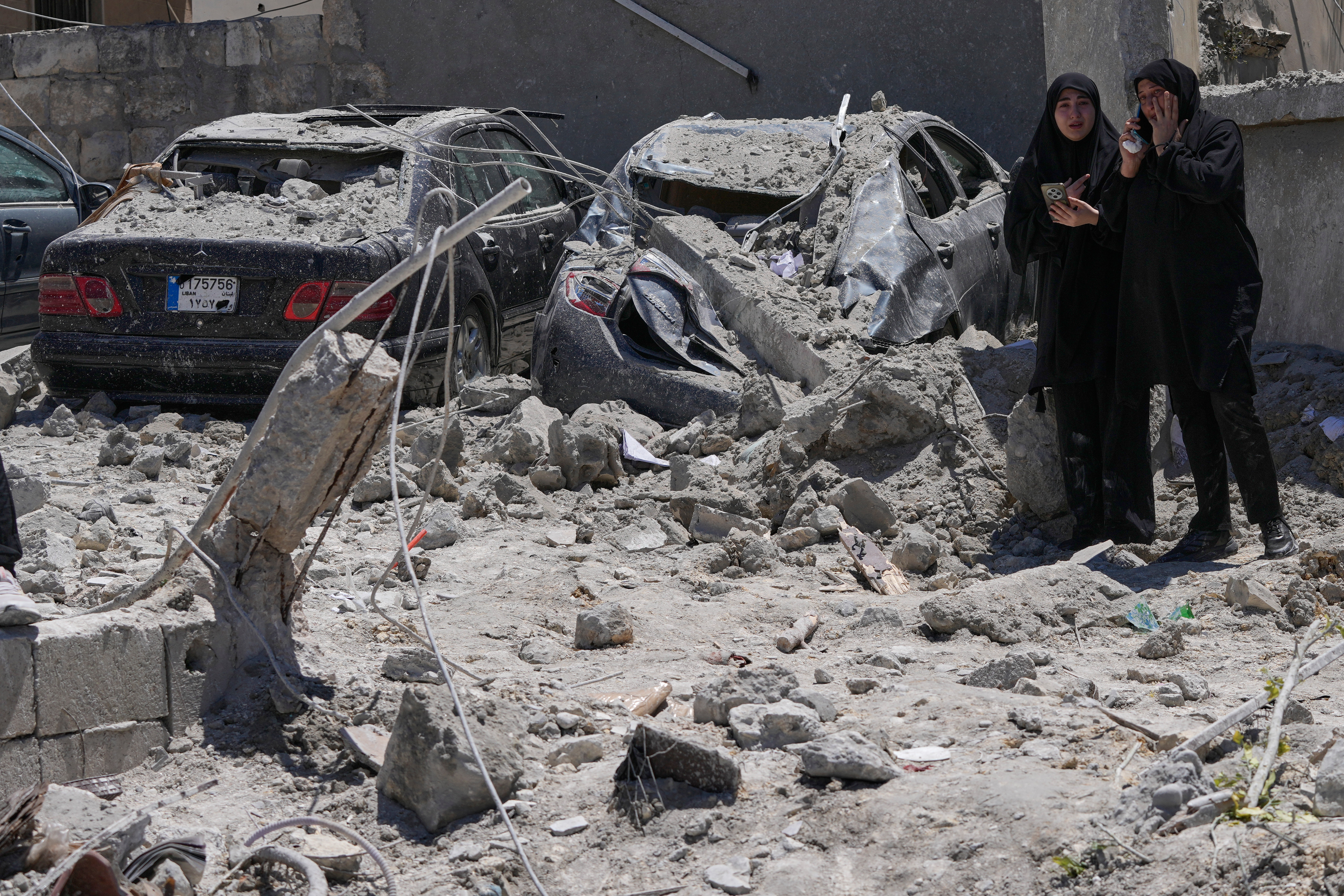 Relatives of missing victims weep, as they gather at the site of destroyed buildings that were hit in an Israeli airstrike in Qannarit village, southern Lebanon, Saturday, June 20, 2026. (AP Photo/Mohammed Zaatari)