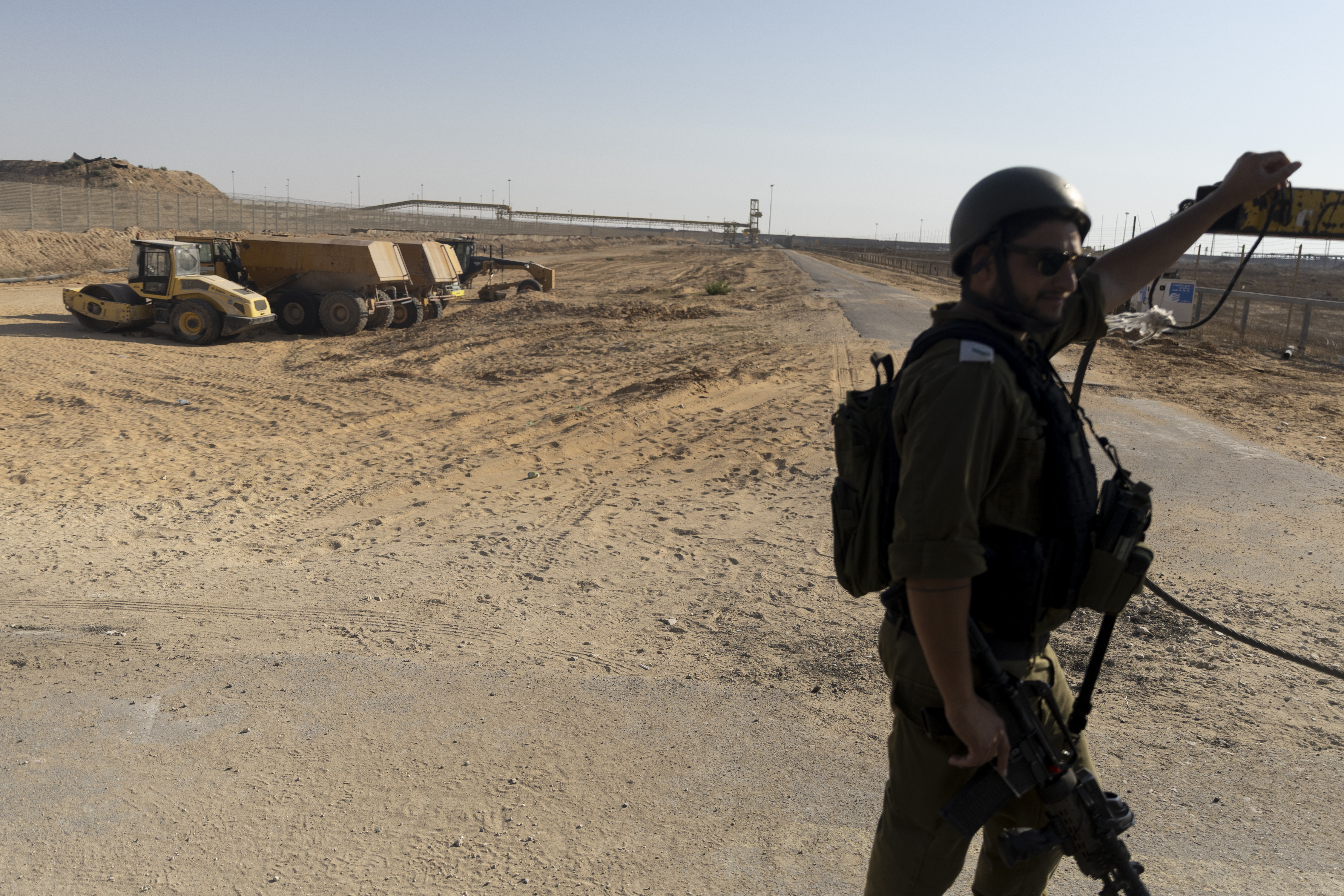 KEREM SHALOM, GAZA STRIP - JULY 24: (EDITORS NOTE: Image has been reviewed by IDF prior to transmission) An Israeli soldier opens a gate to the Gaza Strip on July 24, 2025 in Kerem Shalom, Gaza Strip. The Israel Defense Forces (IDF) has led members of the media on a tour of the Kerem Shalom Crossing in Gaza, following international condemnation of Israel's blockade of humanitarian aid into Gaza. The World Health Organization has said it is "witnessing a deadly surge in malnutrition-related deaths," while more than 100 aid organizations, including Save the Children and Mèdecins Sans Frontières (Doctors Without Borders), issued an open letter warning of mass starvation in Gaza, and imploring Israeli authorities to provide safe access to food aid. Israel claims the hunger crisis in Gaza is a"man-made shortage engineered by Hamas." (Photo by Amir Levy/Getty Images)