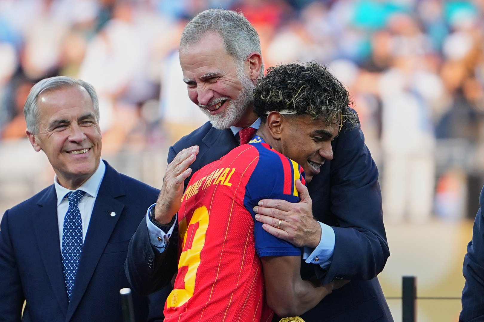 King Felipe VI of Spain, congratulates Spain's Lamine Yamal (19) as Canada Prime Minister Mark Carney looks on after the World Cup final soccer match between Spain and Argentina in East Rutherford, N.J., near New York, Sunday, July 19, 2026. [AP Photo/Julio Cortez]