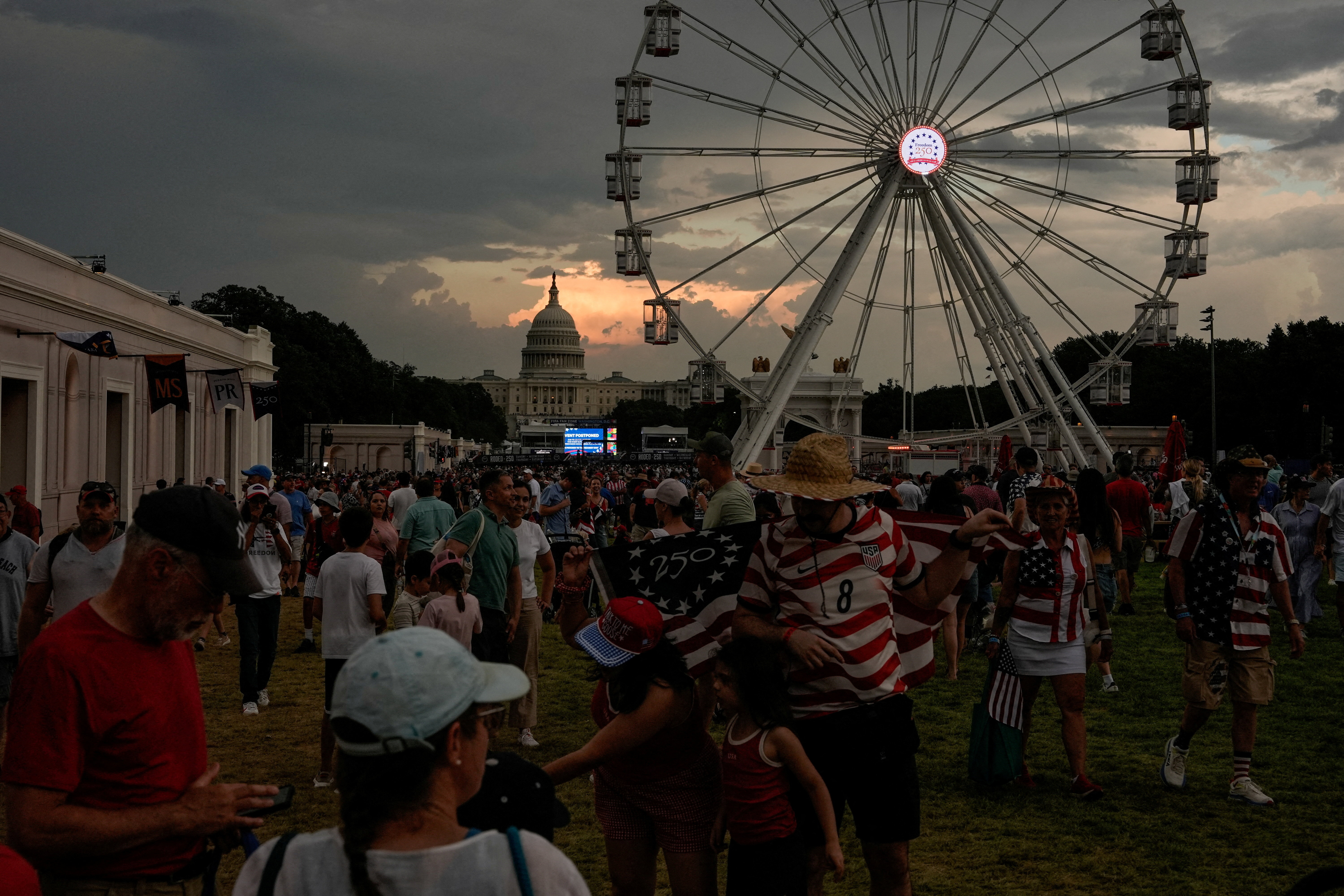 People attend the Great American State Fair on the National Mall, marking the 250th anniversary of U.S. Independence, as inclement weather moves across the area, in Washington, D.C., U.S., July 4, 2026. REUTERS/Cheney Orr TPX IMAGES OF THE DAY