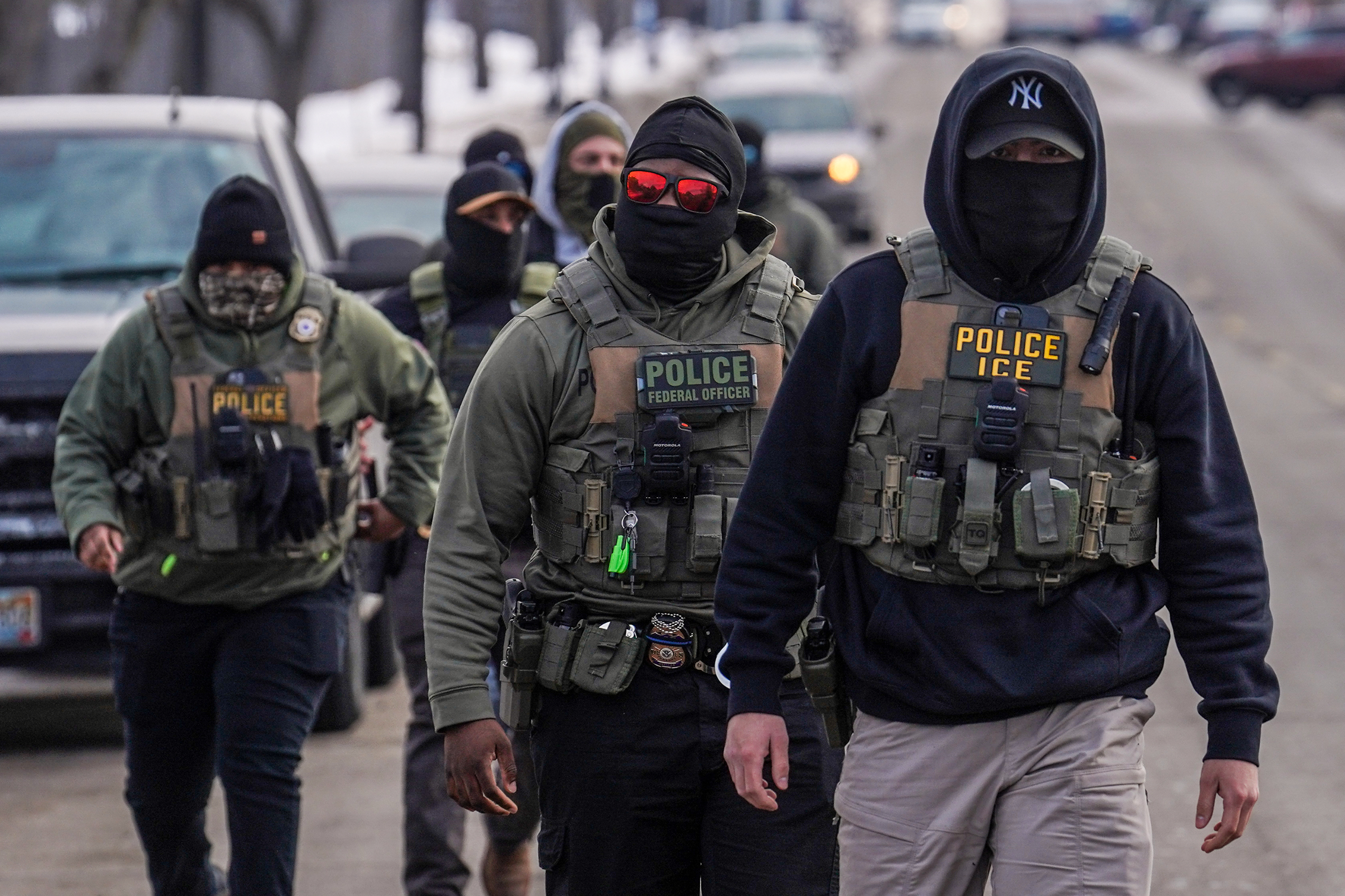 Federal agents walk down a street.