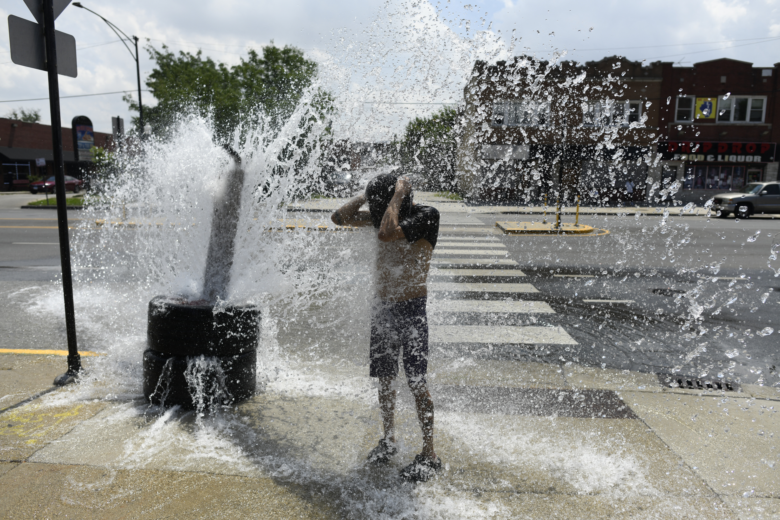 (FILES) A person cools off with water from an open fire hydrant during a heat wave on the West Side of Chicago, Illinois, on July 2, 2026.