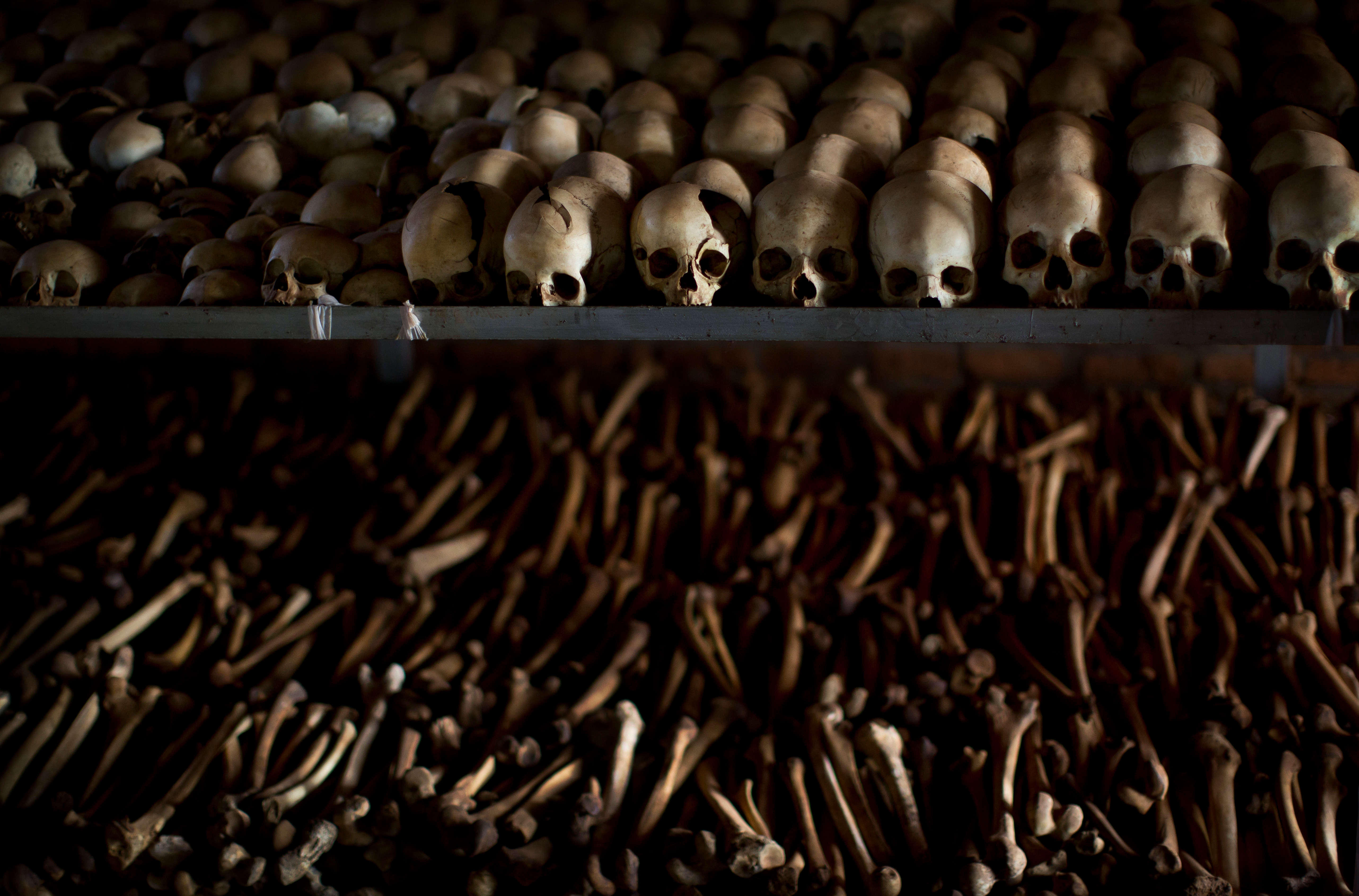 FILE - The skulls and bones of some of those who were slaughtered as they sought refuge inside the church are laid out as a memorial to the thousands who were killed in and around the Catholic church during the 1994 genocide in Ntarama, Rwanda on April 4, 2014. (AP Photo/Ben Curtis, File)