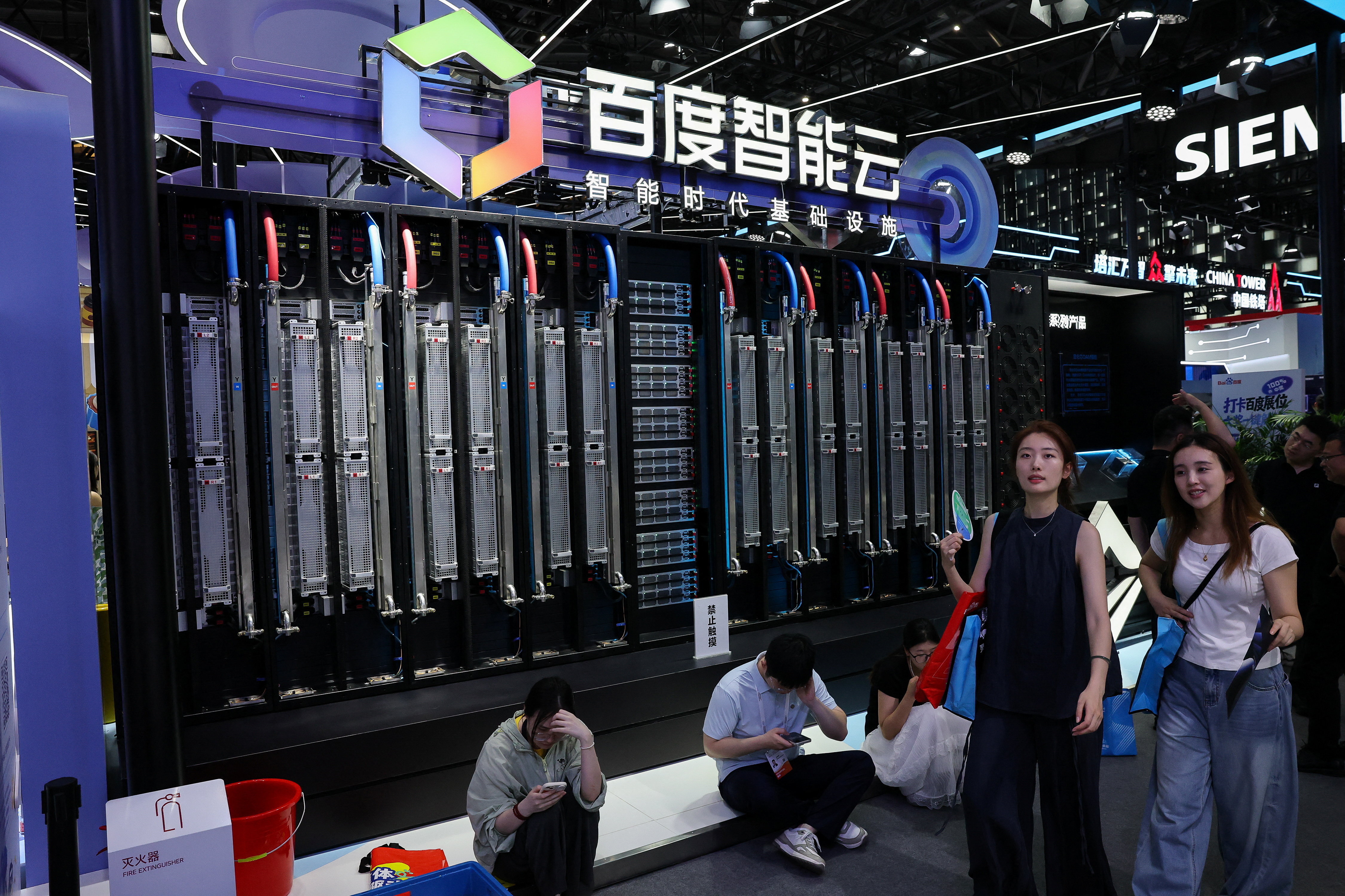 People walk past the Baidu booth, where the Baidu Intelligent Cloud Tianchi 512 Supernodes system is displayed, during the World Artificial Intelligence Conference (WAIC) in Shanghai, China, July 18, 2026. REUTERS/Go Nakamura