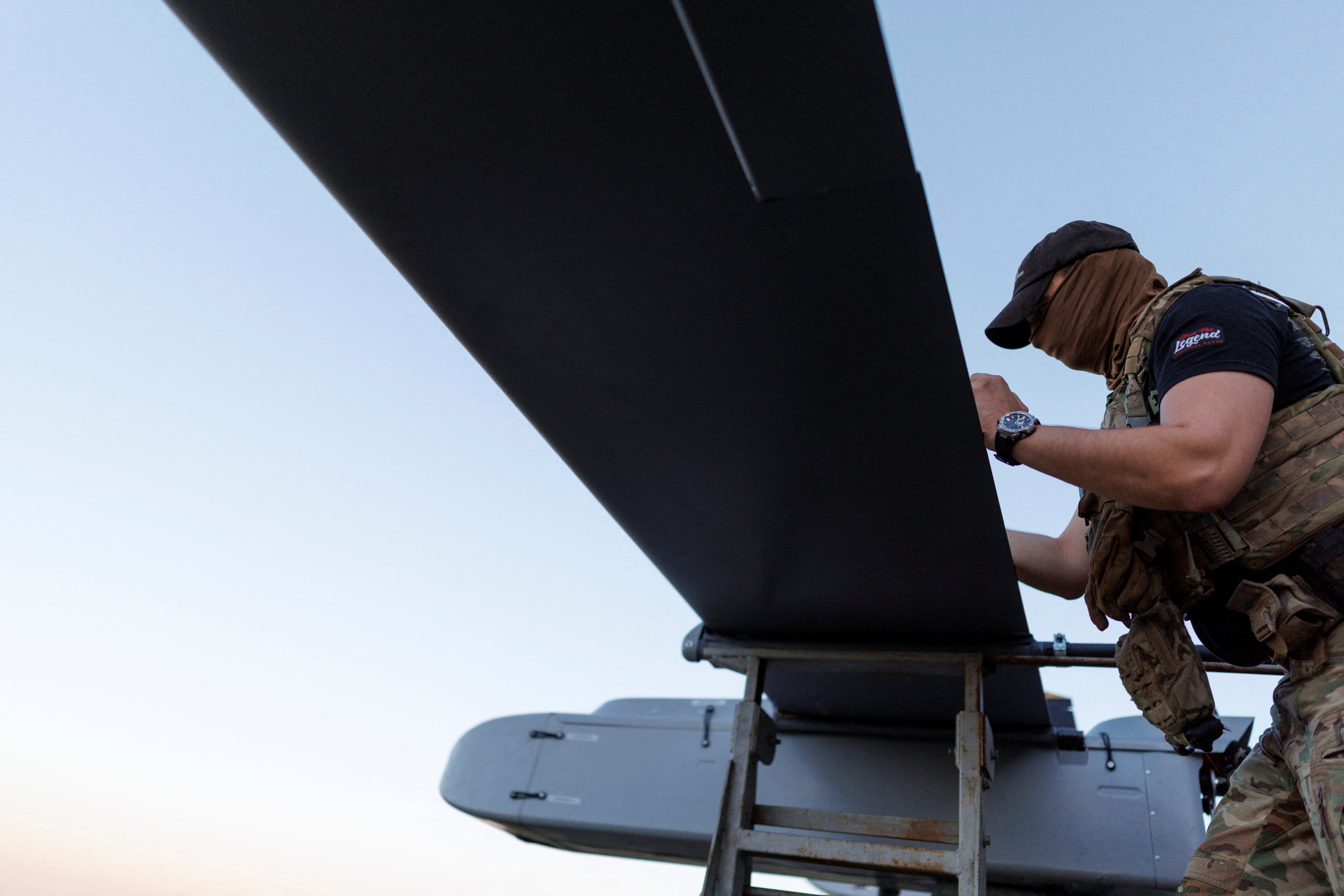 A service member of the 414th Separate Unmanned Strike Aviation System Brigade ‘Magyar’s Birds’ of the Ukrainian Armed Forces writes a message to Russians on an FP-1 deep-strike drone before it launches for a combat mission in an undisclosed location in Ukraine
