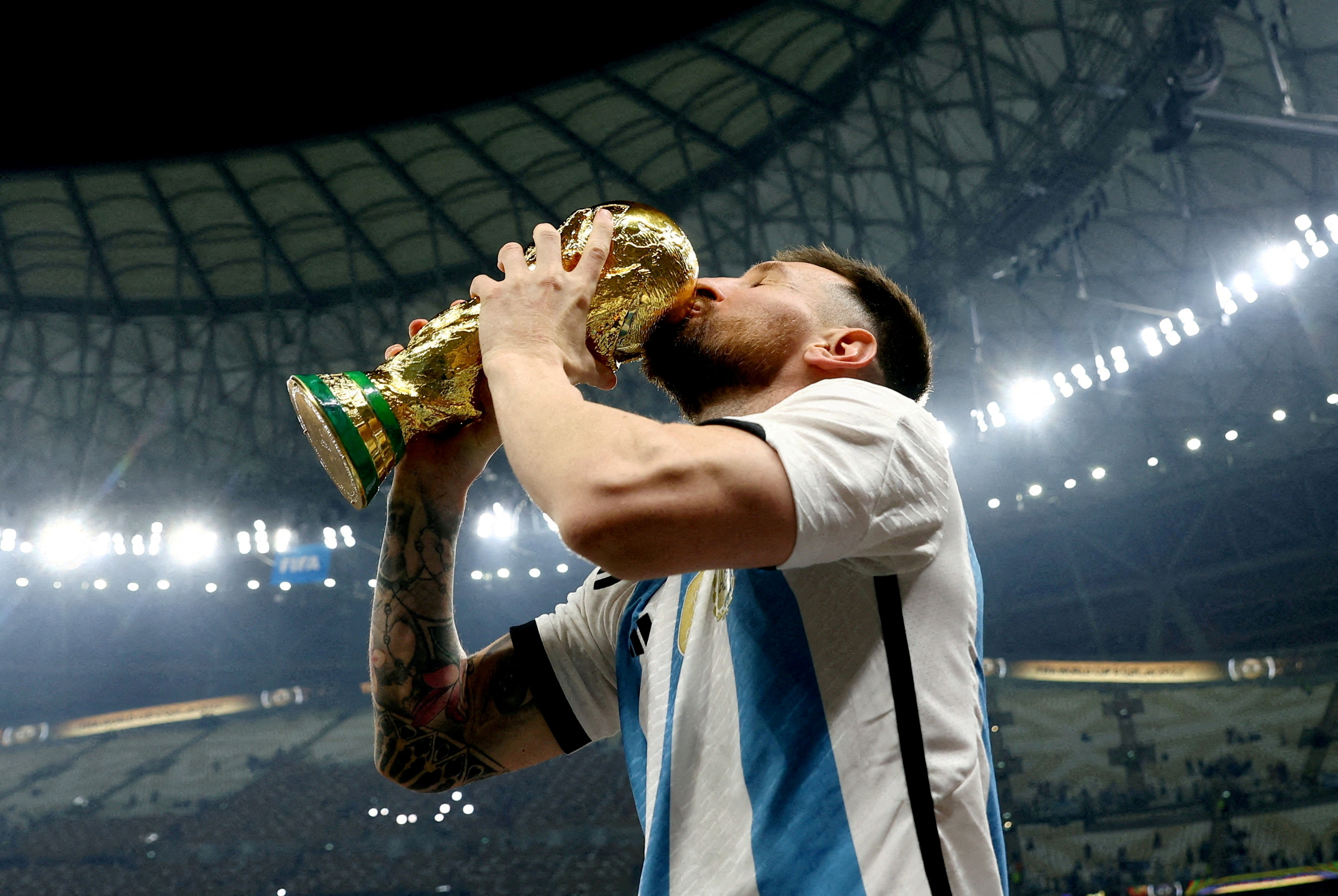 Argentina's Lionel Messi kisses the trophy as he celebrates winning the 2022 football World Cup at Lusail Stadium, Qatar, on December 18, 2022 [File: Hannah Mckay/Reuters]