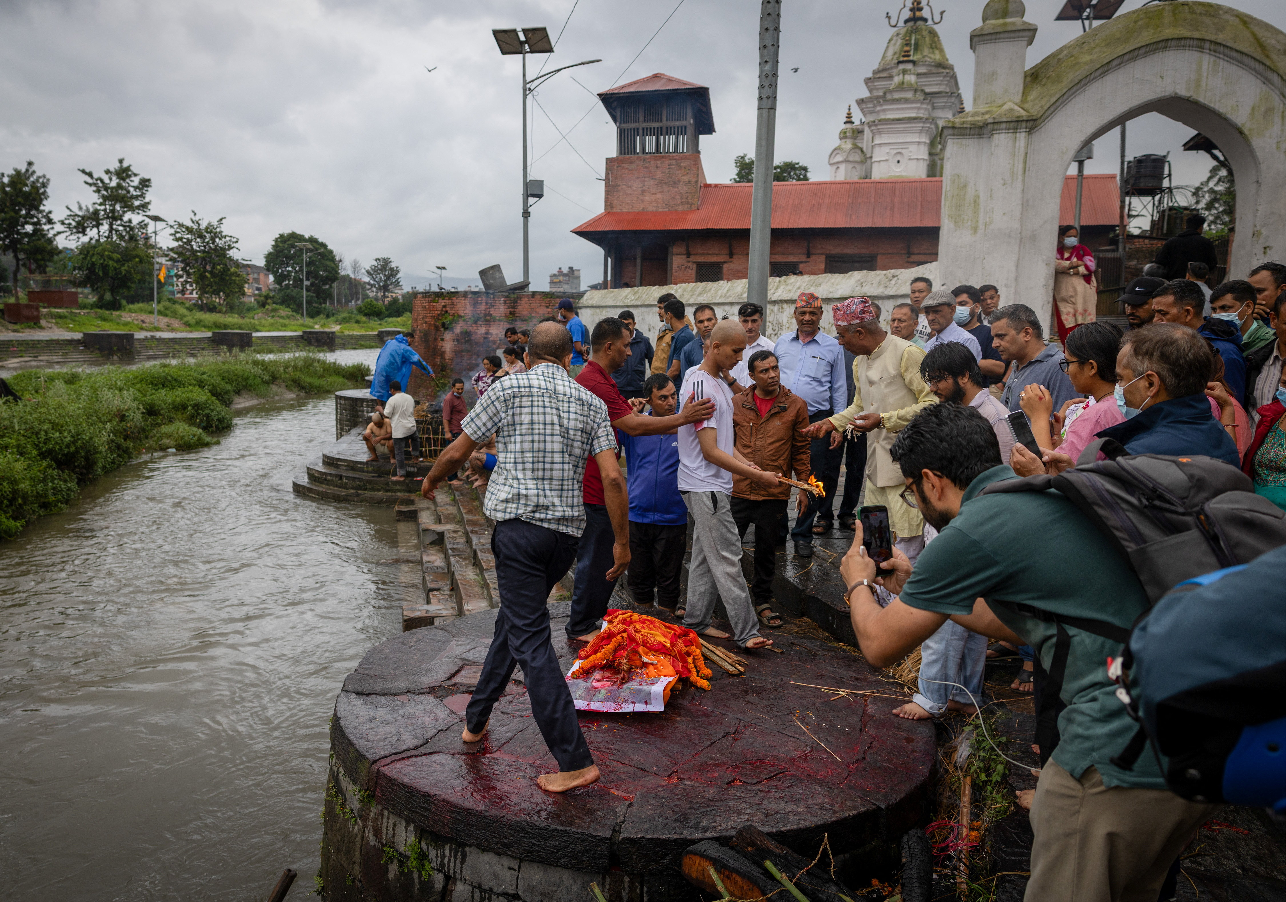 Darshan Bhattarai performs a funeral ritual during the cremation ceremony for his father, Pushpa Raj Bhattarai, 46, who was killed in the floods and a mudslide, using an effigy instead of his father’s body at Pashupatinath Temple in Kathmandu, Nepal, on September 3, 2026