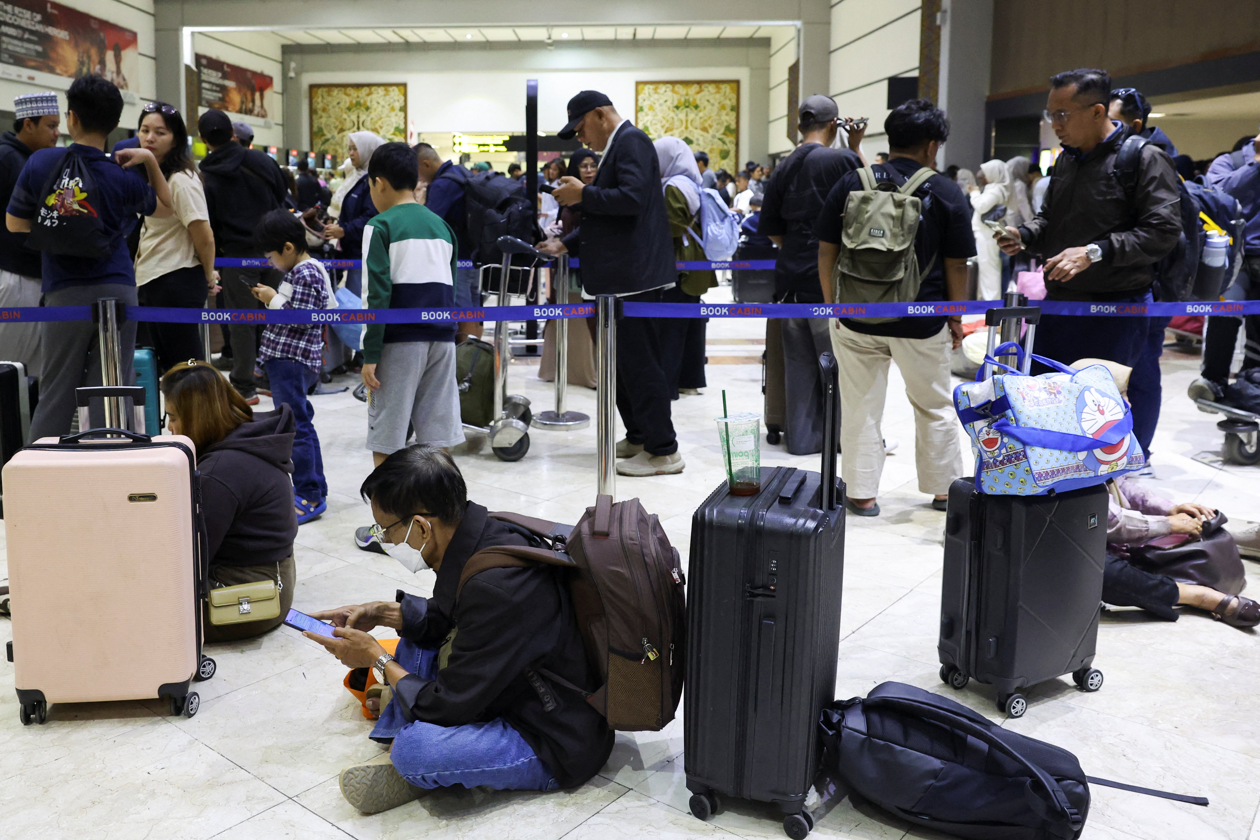 Stranded passengers wait at the check-in area as Soekarno-Hatta International Airport near Jakarta, Indonesia, on September 6, 2026 [Ajeng Dinar Ulfiana/Reuters]