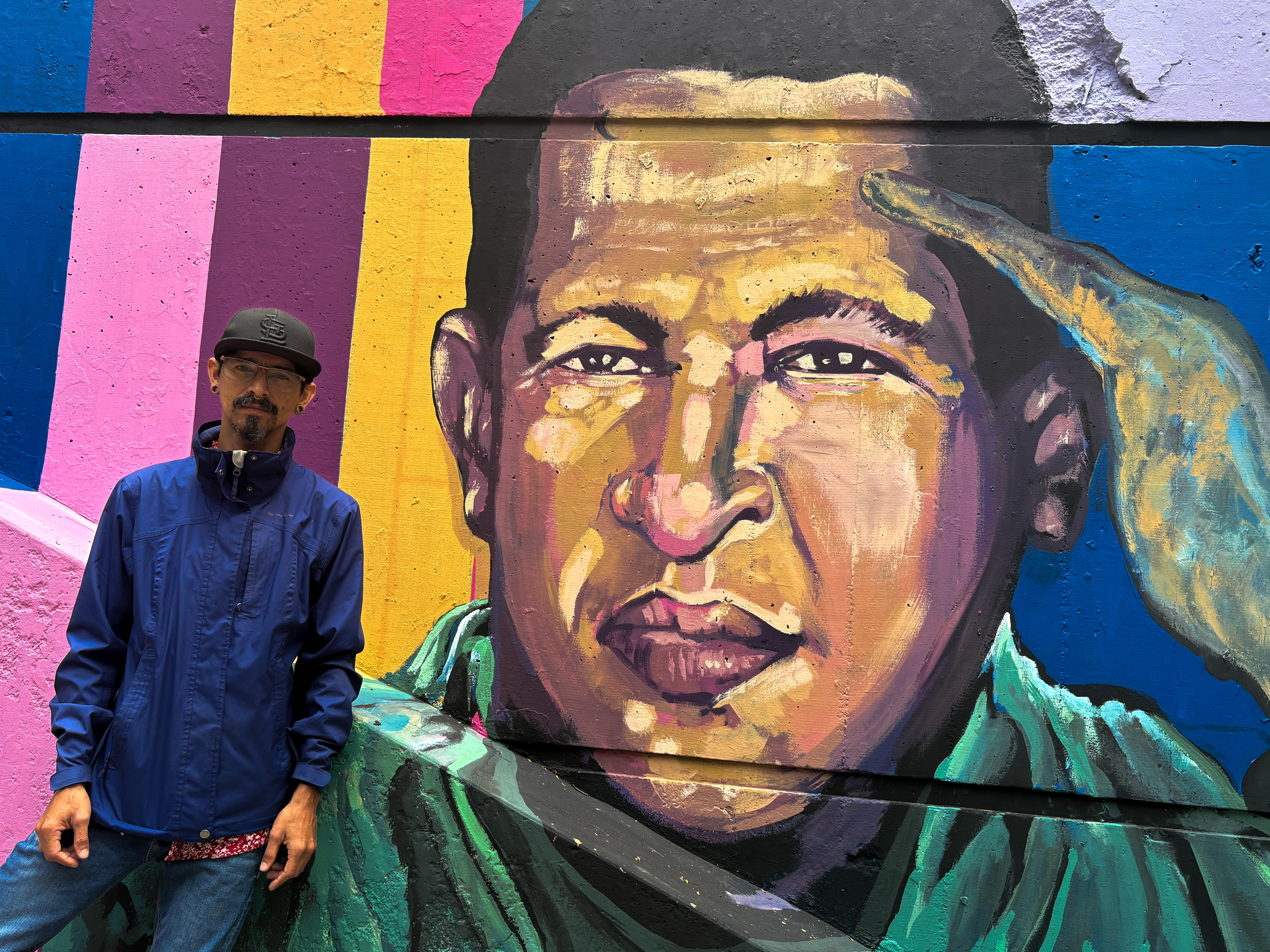 Victor Rodriguez next to one of the murals he painted