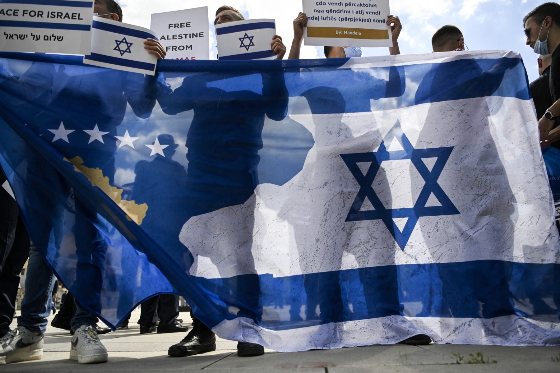 Kosovar Albanian supporters of Israel hold a Kosovo and Israeli flag as they take part in a rally in support of Israel in Pristina on May 21, 2021. A ceasefire between Israel and Hamas, the Islamist movement which controls the Gaza Strip, came into force early May 21, after 11 days of deadly fighting that pounded the Palestinian enclave and forced countless Israelis to seek shelter from rockets. (Photo by Armend NIMANI / AFP)