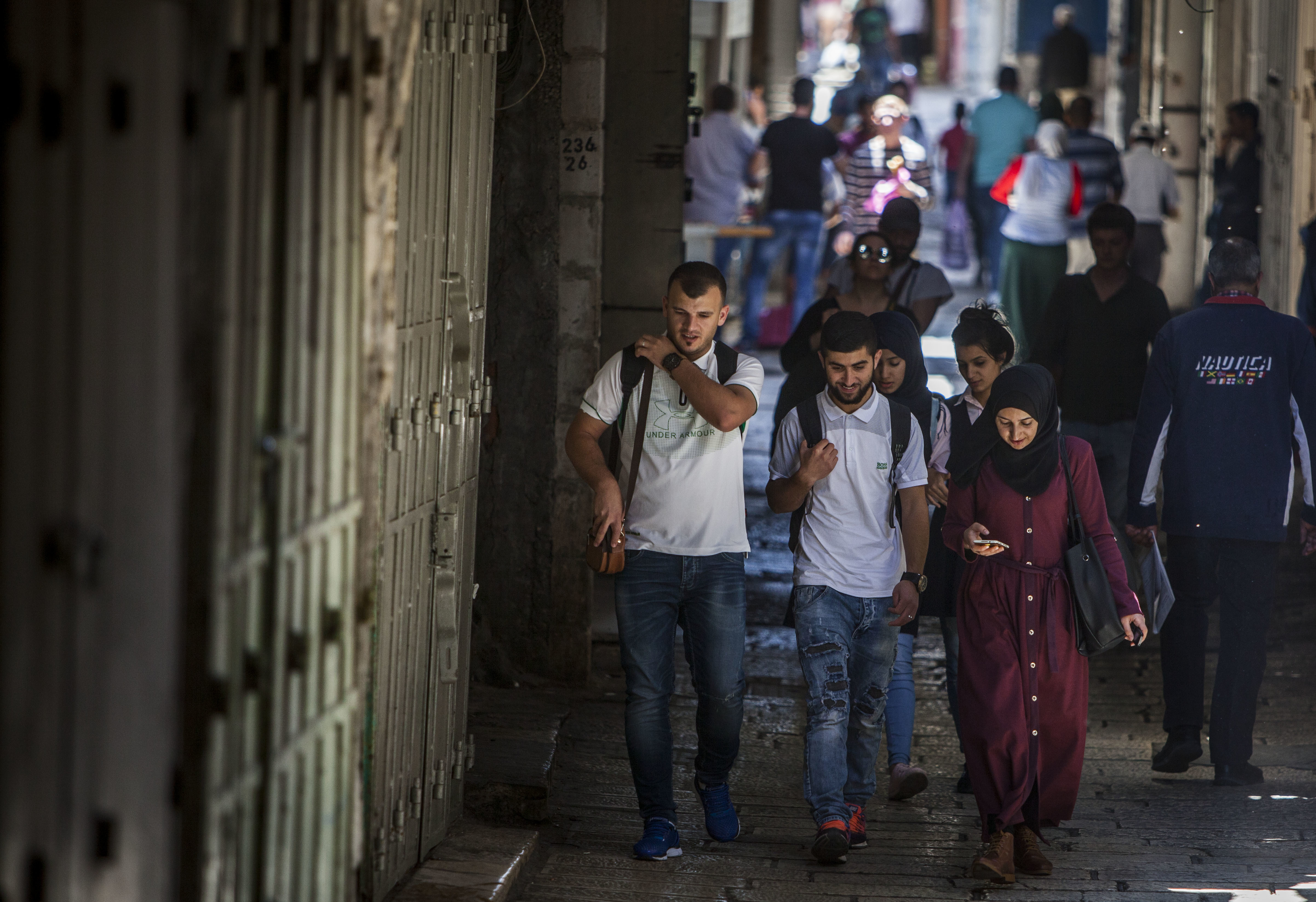 Palestinian students walk down a closed shopping street in Jerusalem's Old City during a general strike, Tuesday, May 15, 2018. Palestinians on May 15 mark the Naqba Day, or catastrophe, when hundreds of thousands of Palestinians fled or were expelled from their homes during the 1948 Israel-Arab war. (AP Photo/Eyal Warshavsky)