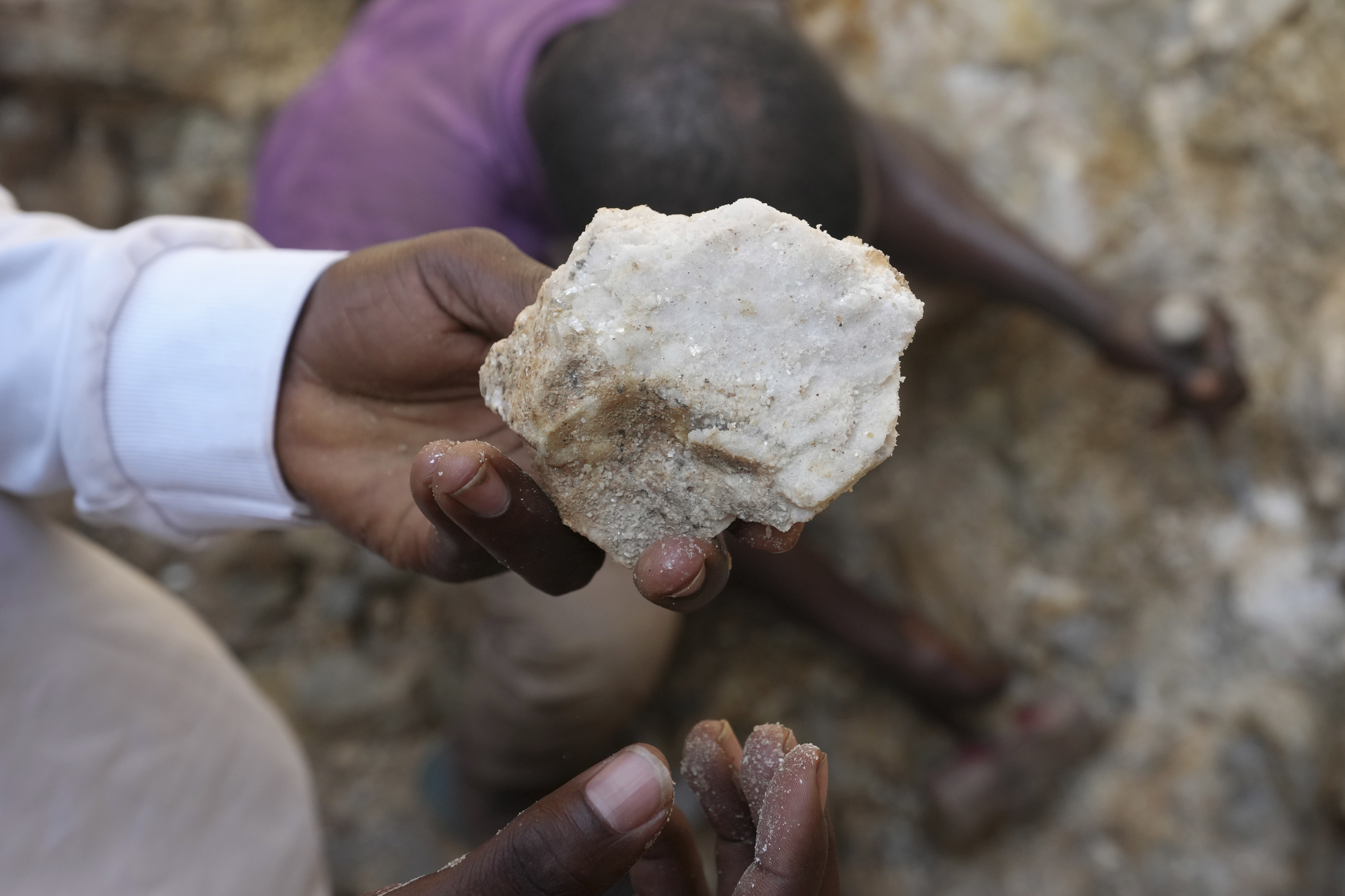 A man shows lithium stone from an illegal mining site in Paseli, north central Nigeria [File: Sunday Alamba/AP]