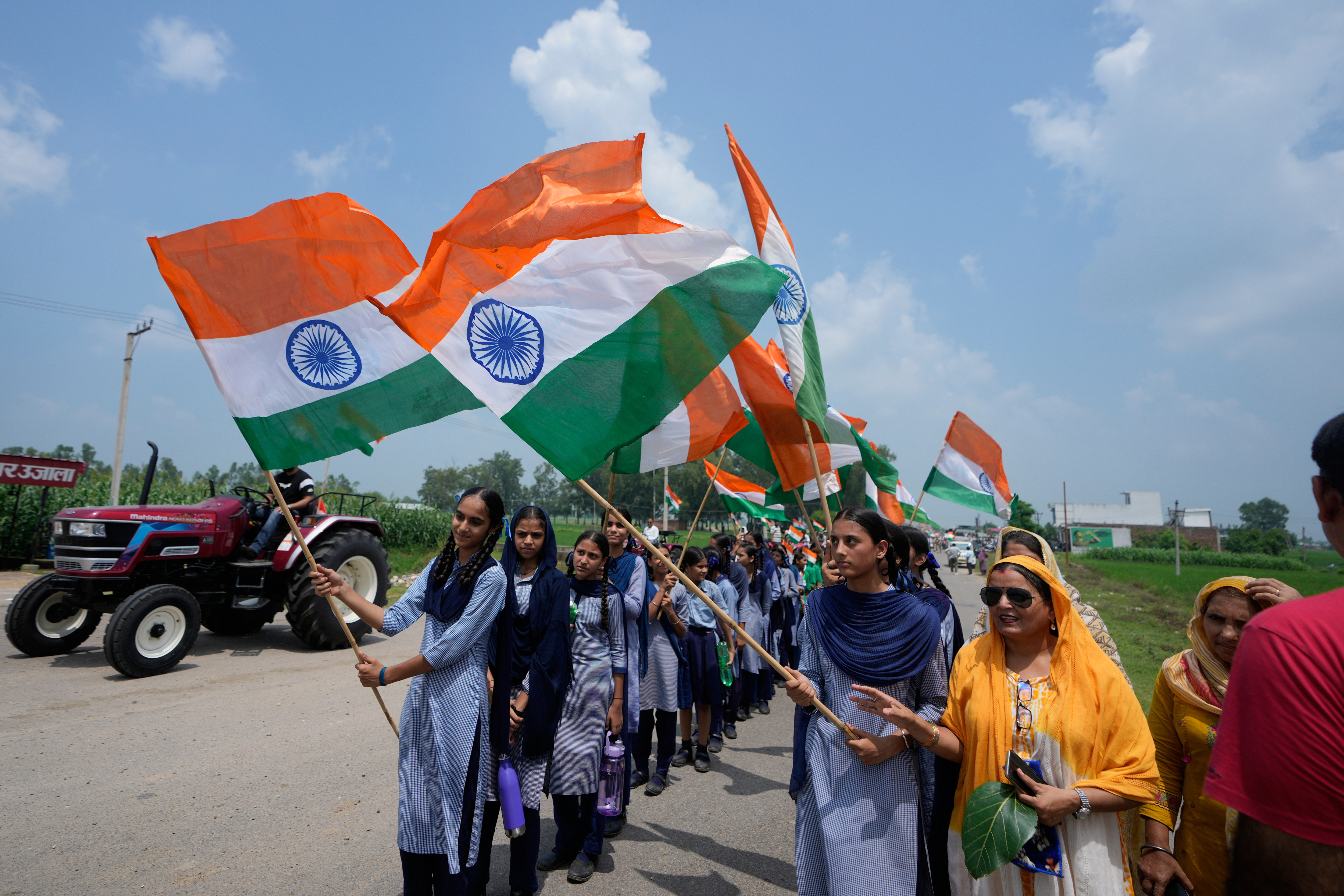 School children holding Indian flags participate in Tiranga Yatra, or the tricolor procession, ahead of India's Independence Day at Ranbir Singh Pura, near the border with Pakistan, Thursday, Aug. 13, 2026. (AP Photo/ Channi Anand)