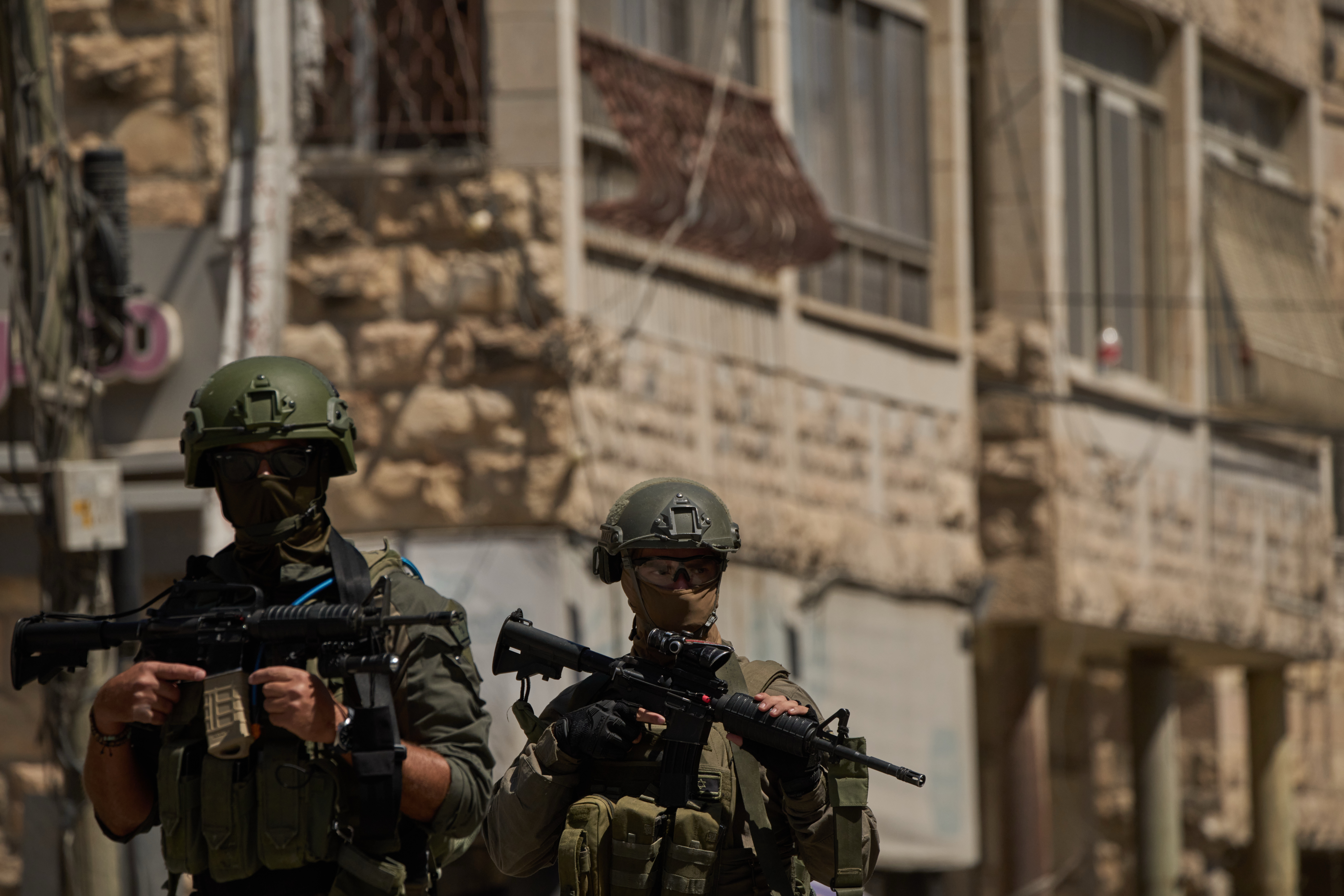 Israeli soldiers move on a street during a raid in the occupied West Bank town of Anata