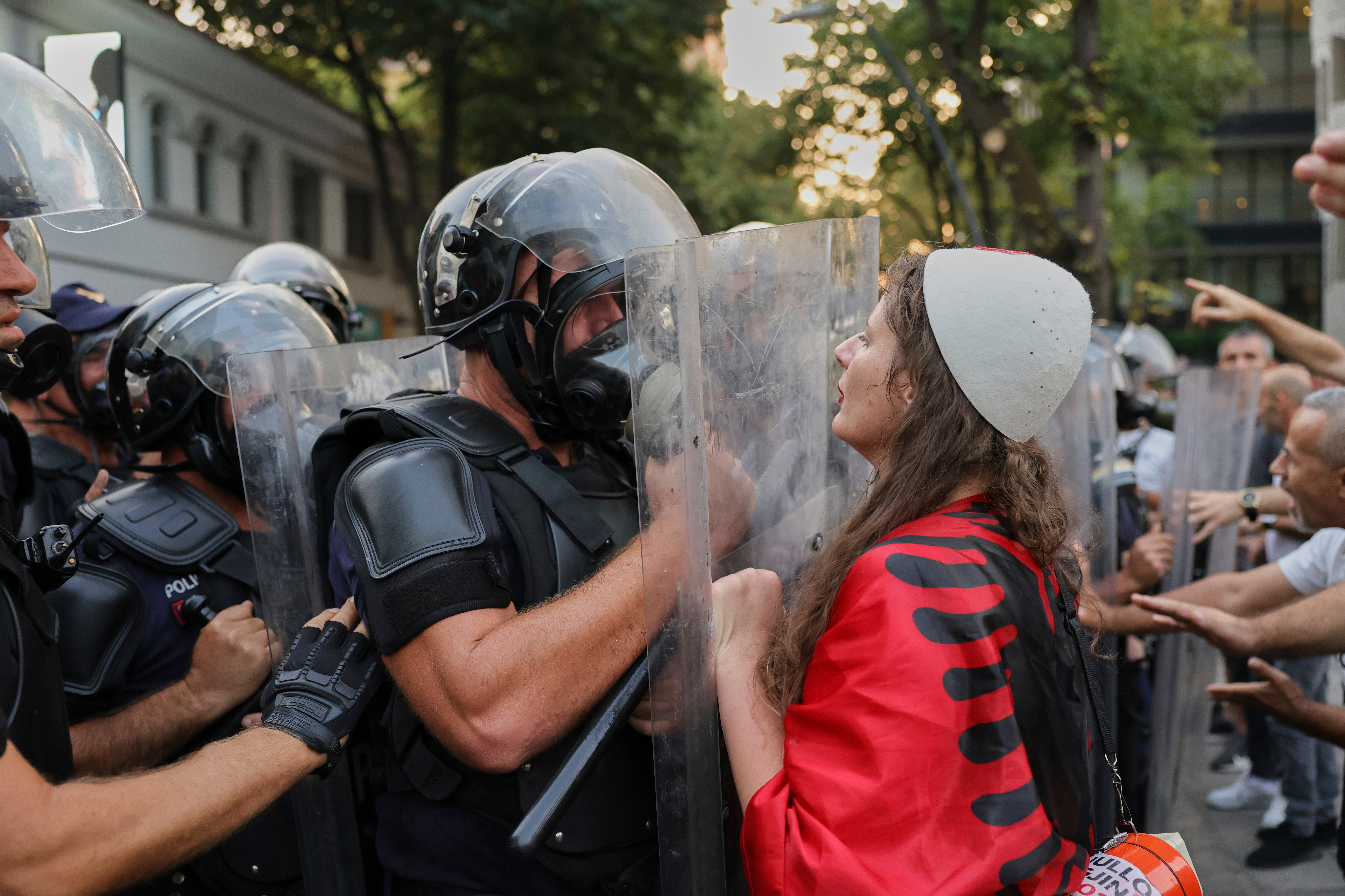 A woman draped in an Albanian flag clashes with police officers during ongoing demonstrations against plans for a luxury resort in a protected coastal area linked to US President Donald Trump's family in Albanian capital Tirana, on Tuesday, Sept. 8, 2026 [Hameraldi Agolli/ AP Photo]