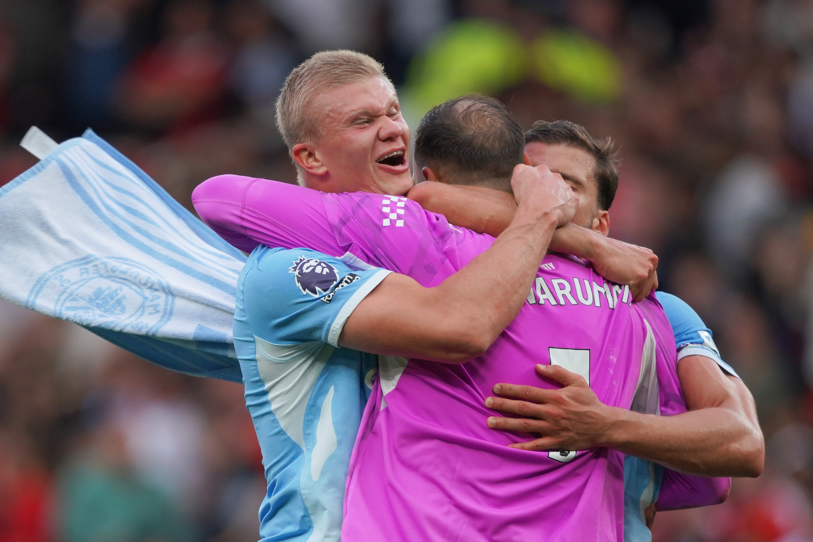 Manchester City's Erling Haaland, left, Manchester City's goalkeeper Gianluigi Donnarumma, Manchester City's Ruben Dias celebrate after the English Premier League soccer match at United
