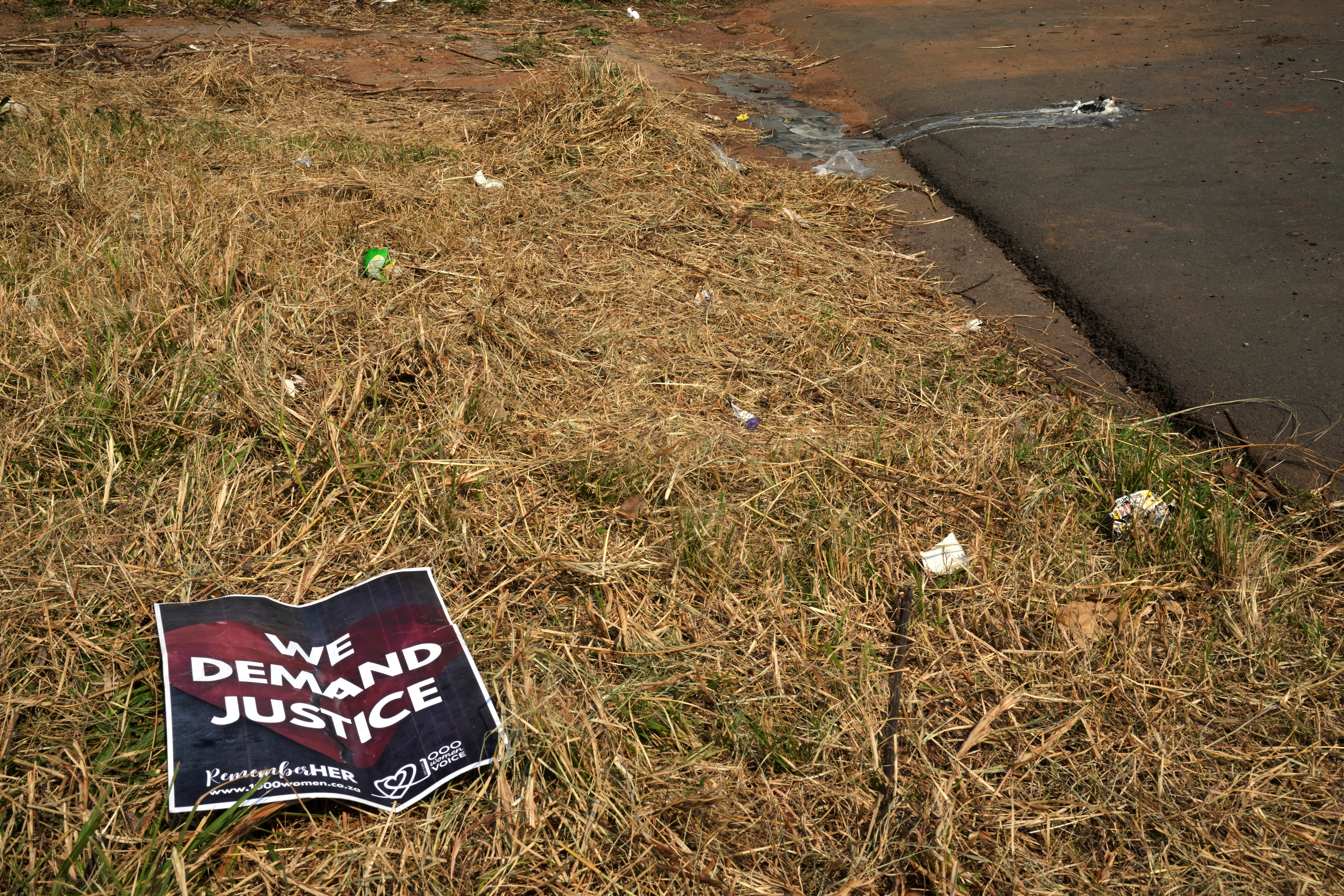A poster is seen at a scene of a discovery of the body of a 38-year-old woman last week while jogging, in Kempton Park, east of Johannesburg, South Africa, Thursday, Sept. 17, 2026. (AP Photo/Themba Hadebe)