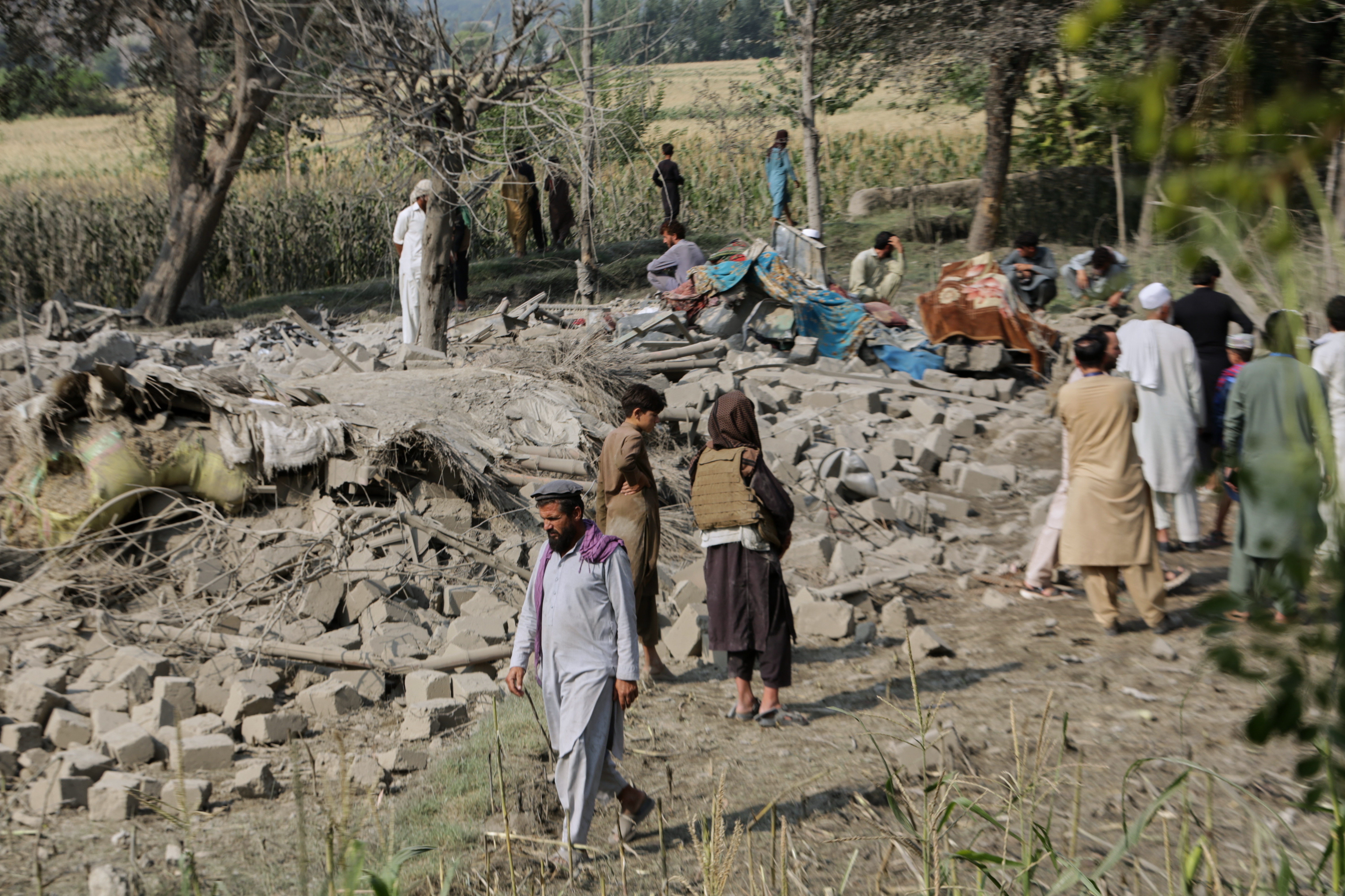 Residents inspect the rubble of a house destroyed in a strike on Patan village, Kunar province